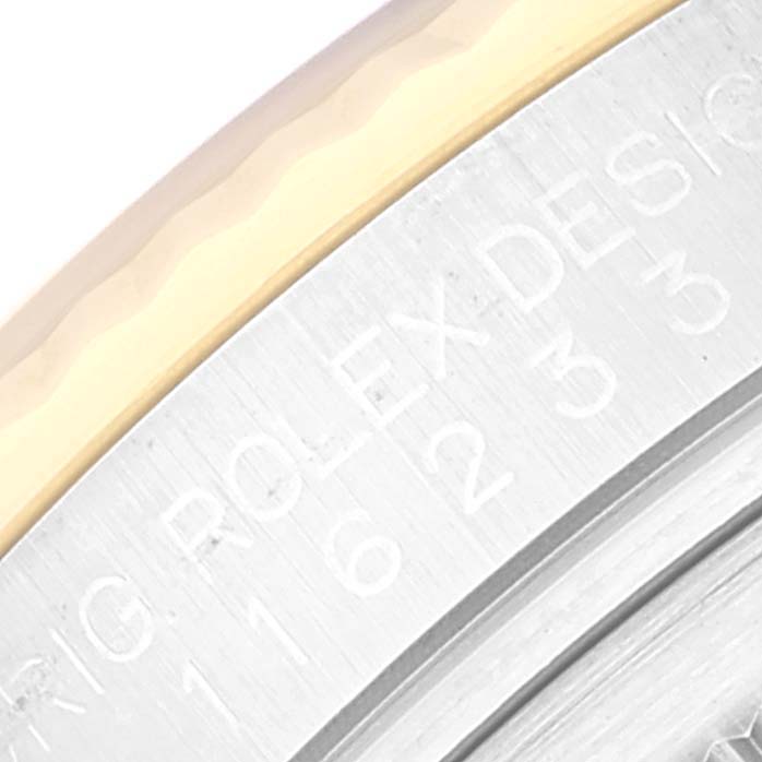 The image shows a close-up of the engraved text on the bezel of a Rolex Datejust 116233 Men's Steel and Gold (two tone) Black Dial 116233 Men's Steel and Gold (two tone) Black Dial watch.