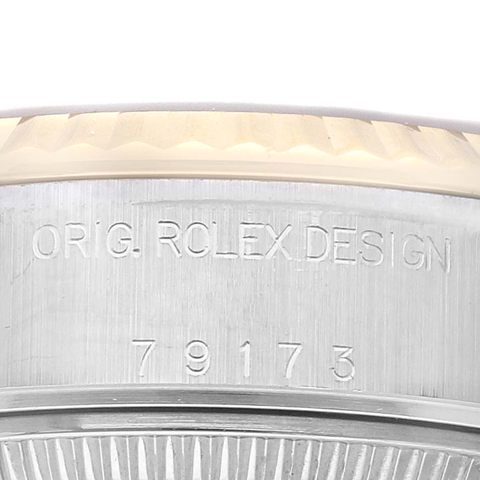 This is a close-up angle of the Rolex Datejust 79173 Women's Steel and Gold (two tone) Champagne Dial 79173 Women's Steel and Gold (two tone) Champagne Dial watch, focusing on the bezel and case with visible engravings.