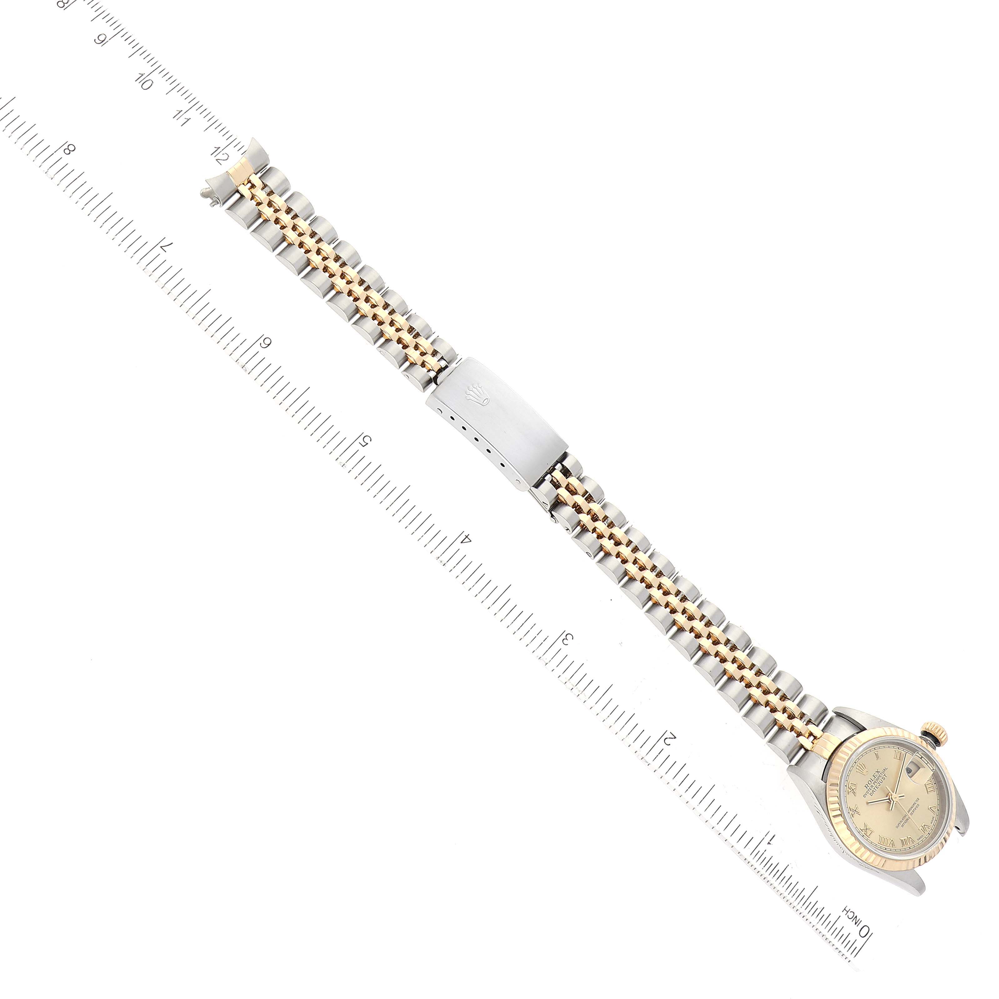 The image shows a Rolex Datejust 79173 Women's Steel and Gold (two tone) Champagne Dial 79173 Women's Steel and Gold (two tone) Champagne Dial watch from a top-down angle, highlighting the face, bezel, and two-tone bracelet with deployant buckle.