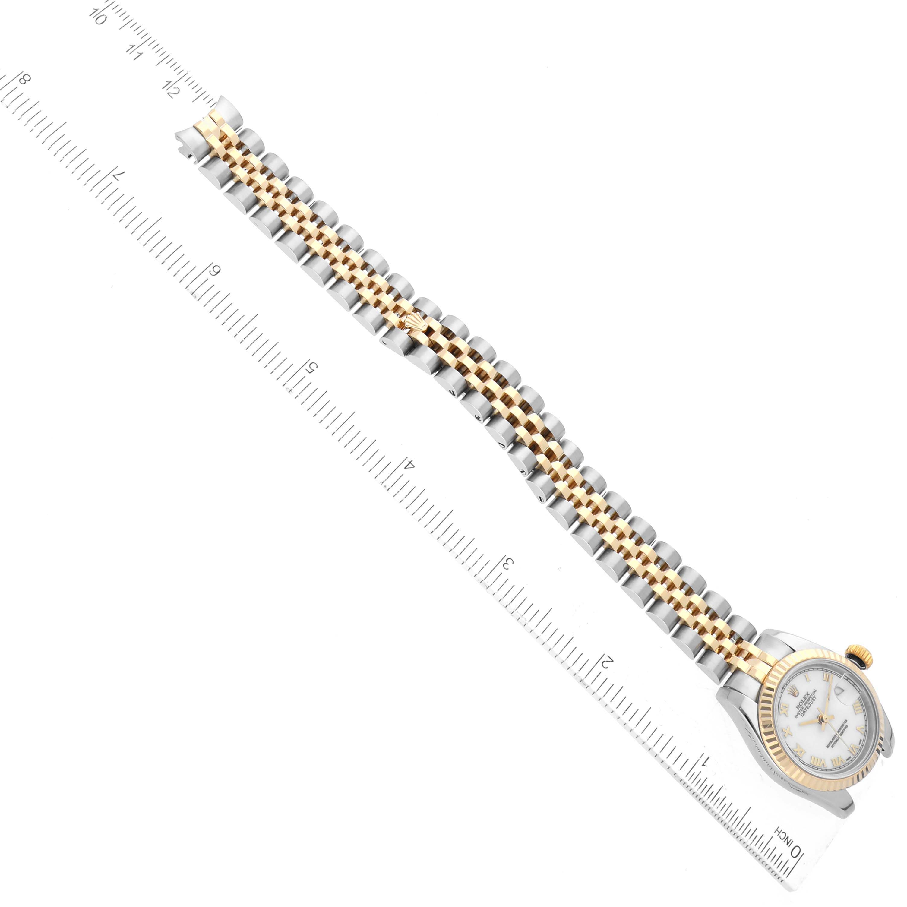 The image shows a Rolex Datejust 179173 Women's Steel and Gold (two tone) White Dial 179173 Women's Steel and Gold (two tone) White Dial watch from a top-down angle, highlighting the dial, bezel, and two-tone metal bracelet alongside a ruler.