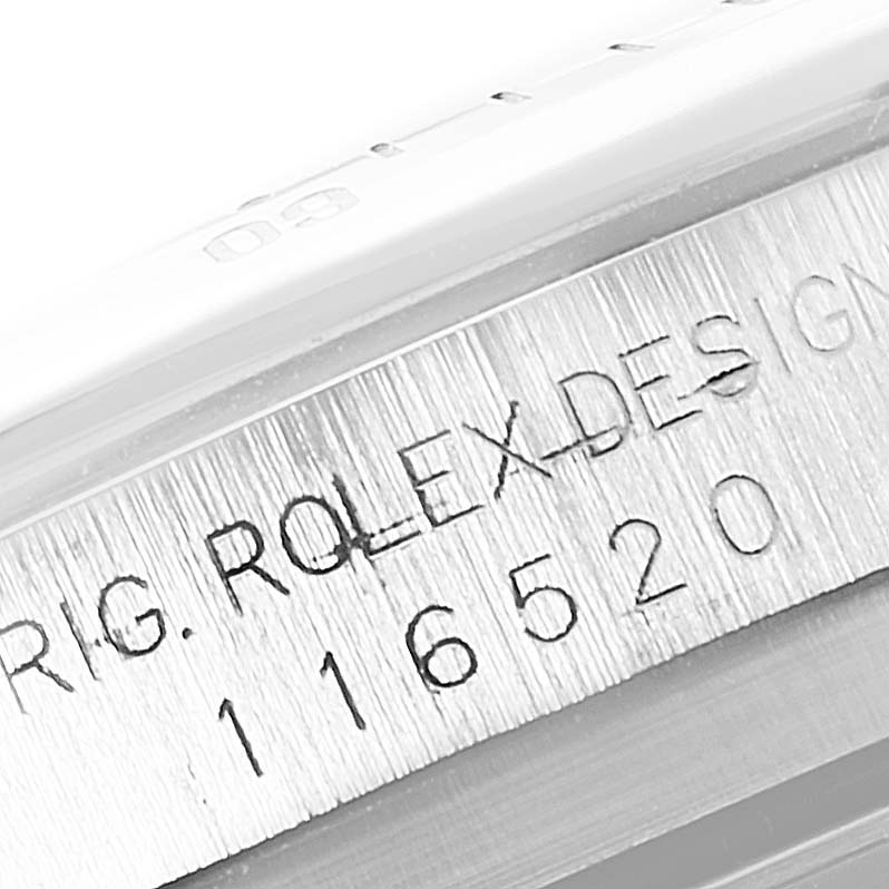The image shows a close-up view of the engraved serial number on the side of a Rolex Daytona 116520 Men
s Stainless Steel Black Dial 116520 Men
s Stainless Steel Black Dial watch.