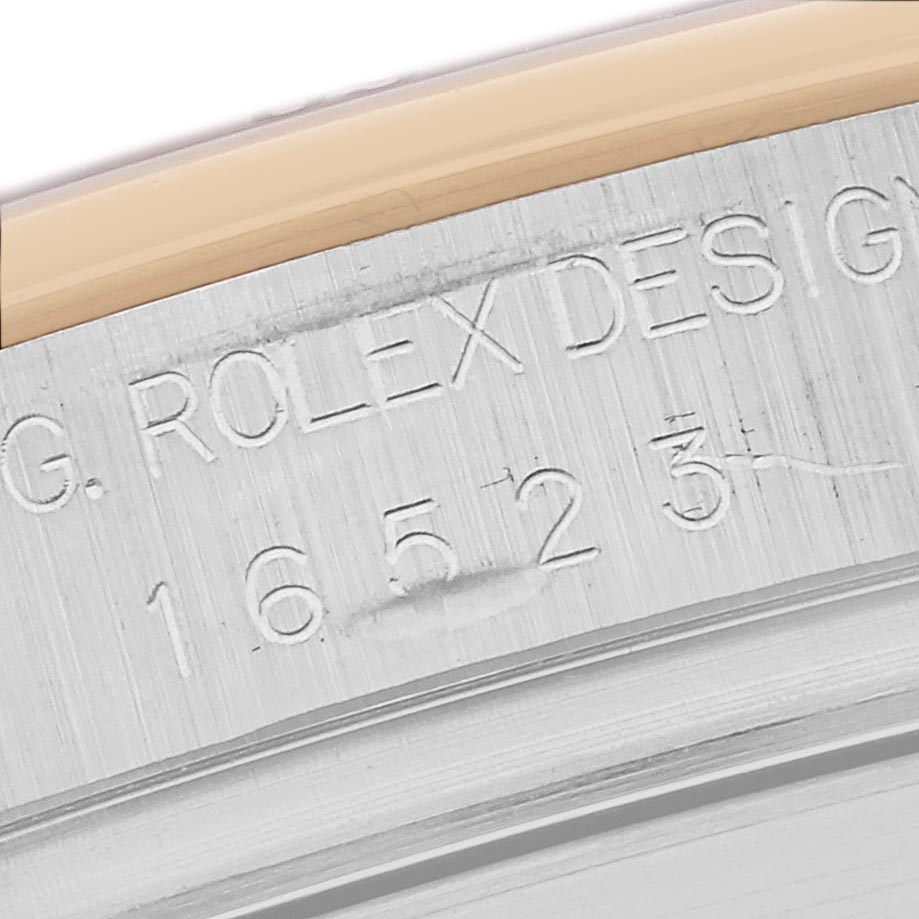 The image shows an angled view of the engraved edge of a Rolex Daytona 16523 Men's Steel and Gold (two tone) Black Dial 16523 Men's Steel and Gold (two tone) Black Dial watch with a visible reference number.