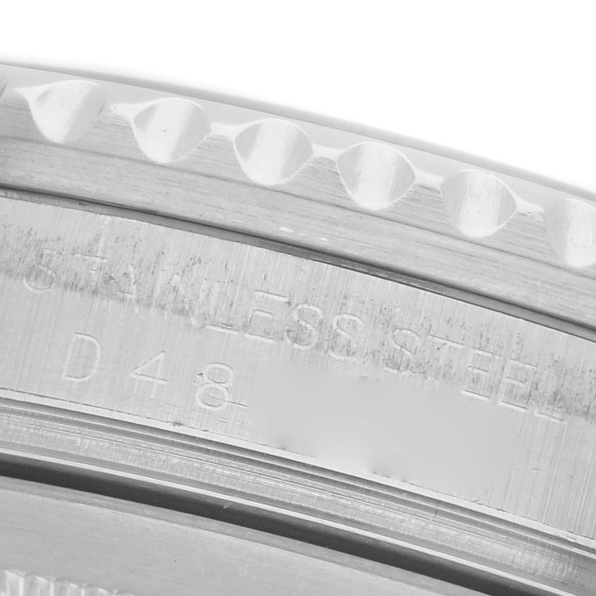 The image shows a close-up of the bezel and engraved side of a Rolex GMT-Master 16710 Men's Stainless Steel Black Dial 16710 Men's Stainless Steel Black Dial, highlighting the stainless steel material.