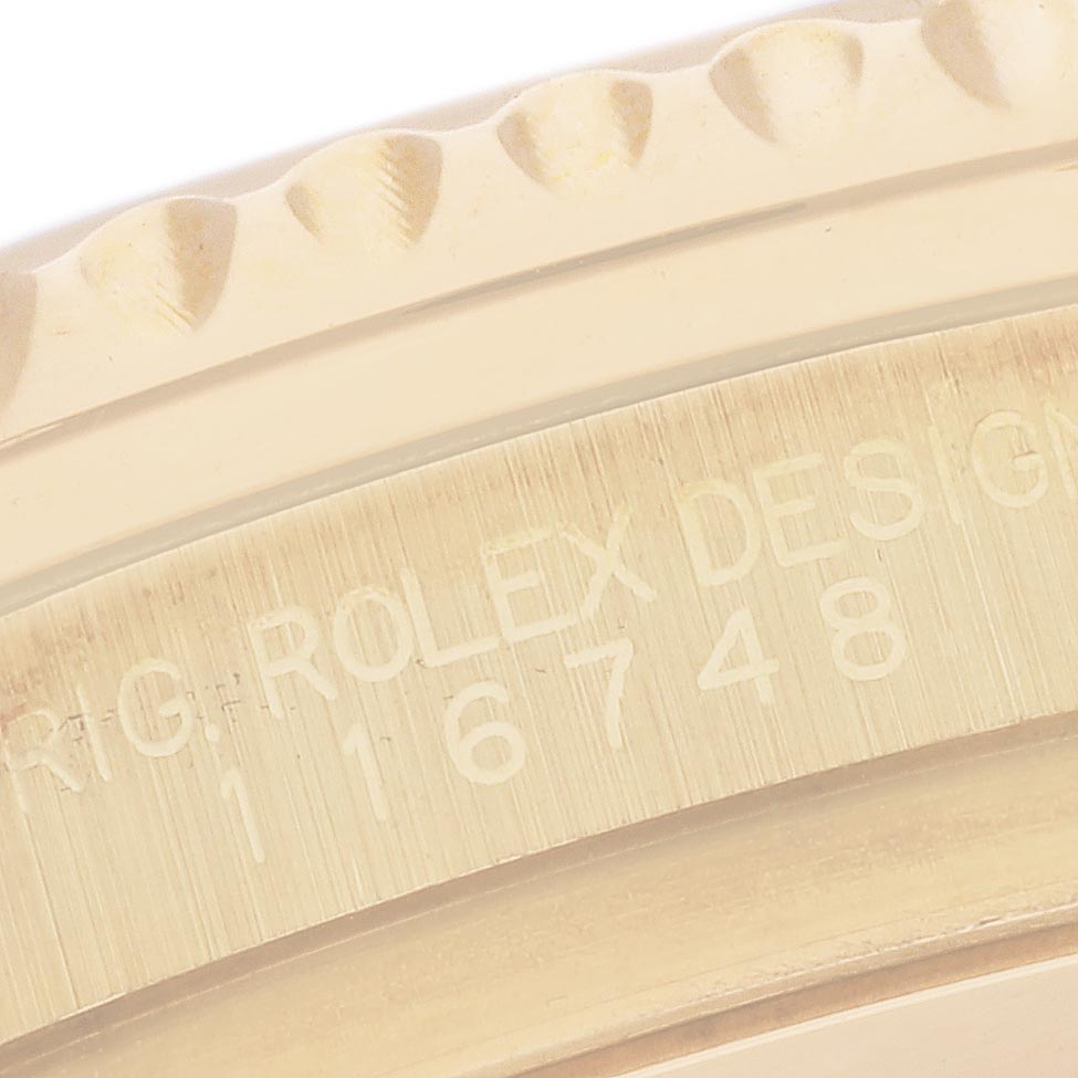 This close-up of the Rolex GMT-Master 116748 Men's Yellow Gold Black Dial 116748 Men's Yellow Gold Black Dial shows the engraved model number on the side of the watch case and part of the bezel edge.