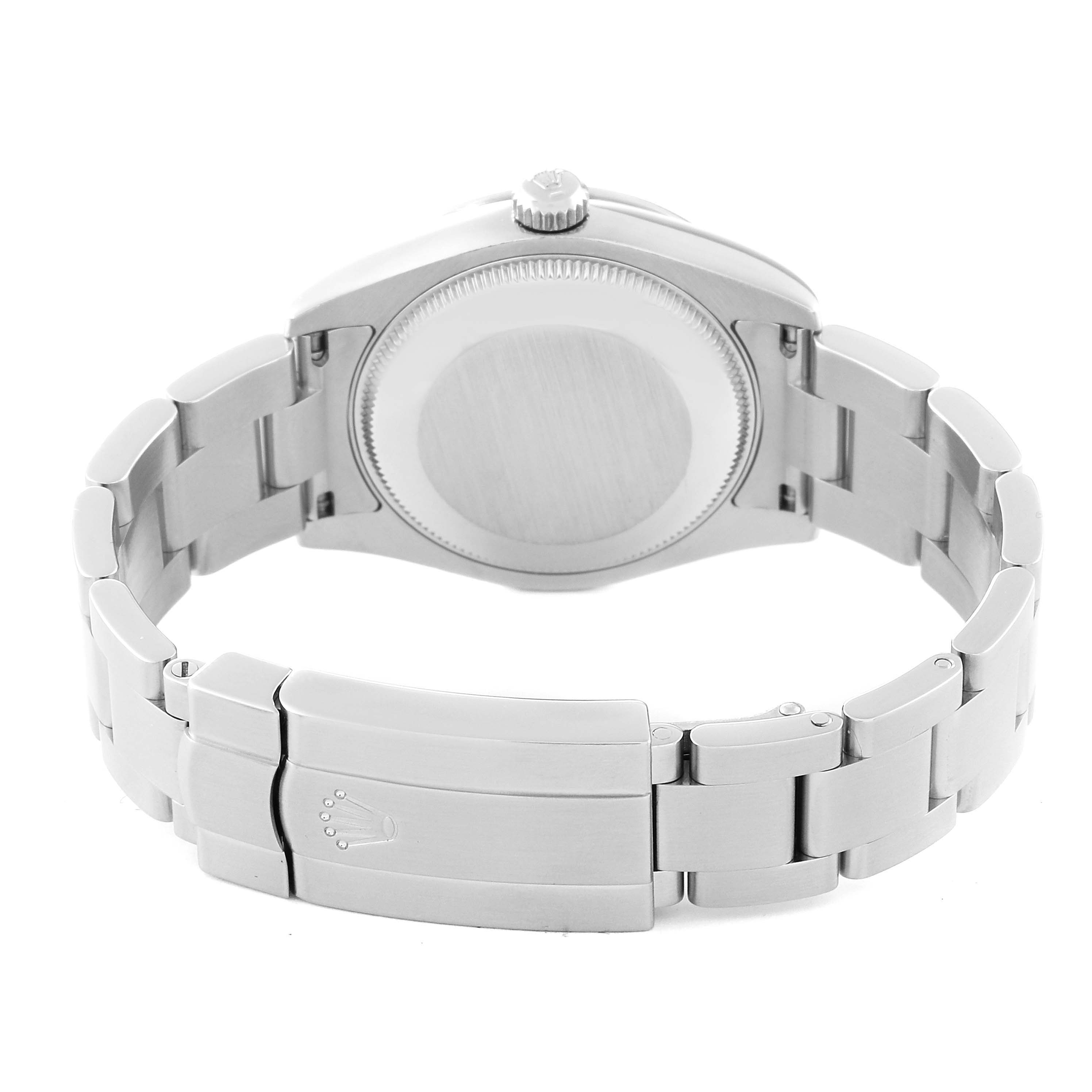 The image shows the backside of a mid-size Rolex watch, highlighting its case back, crown, and stainless steel bracelet with clasp.