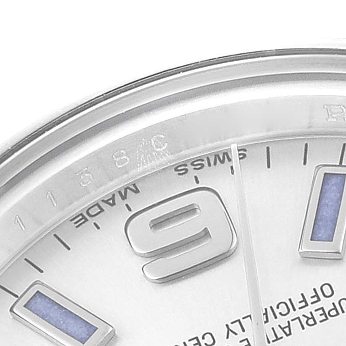 The image shows a close-up of the dial and indices on an Oyster Perpetual model by Rolex, focusing on the 9 o'clock marker.