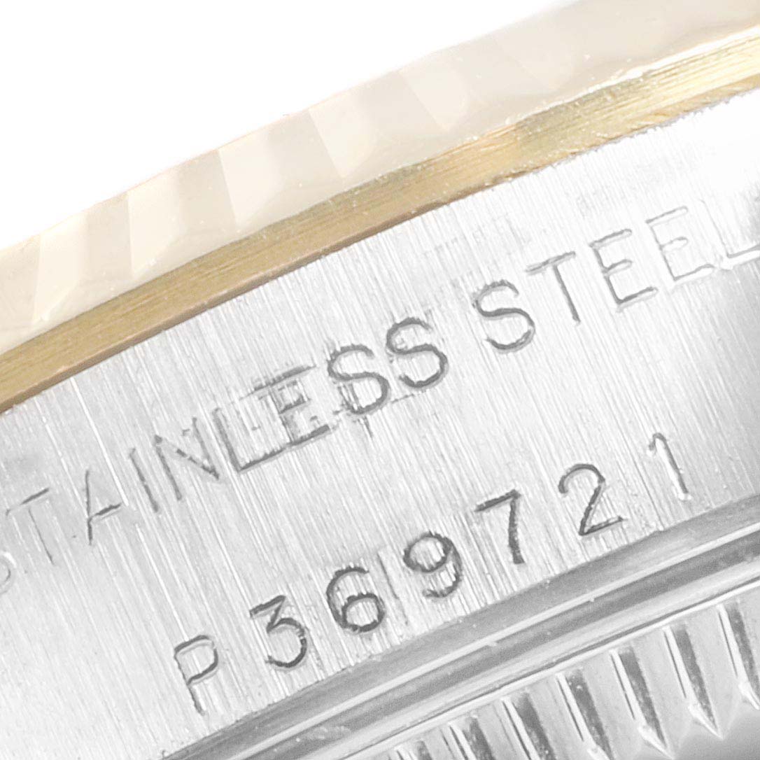 The image shows a close-up view of the Rolex Oyster Perpetual 76193 Women's Stainless Steel Grey Dial 76193 Women's Stainless Steel Grey Dial watch case with engravings indicating the serial number and the stainless steel material.