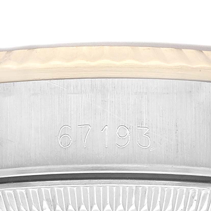 This image shows a close-up of the engraved serial number on the side of a Rolex Oyster Perpetual 67193 Women's Steel and Gold (two tone) Champagne Dial 67193 Women's Steel and Gold (two tone) Champagne Dial watch case.