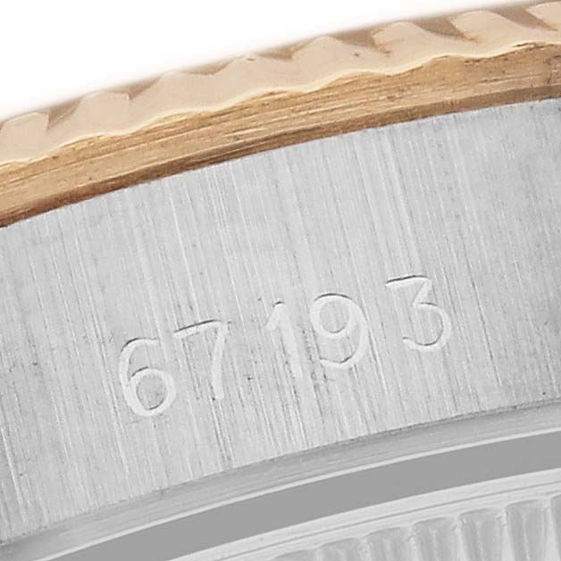 This image shows a close-up of the rim and engraved serial number of a Rolex Oyster Perpetual 67193 Women's Steel and Gold (two tone) Champagne Dial 67193 Women's Steel and Gold (two tone) Champagne Dial watch.