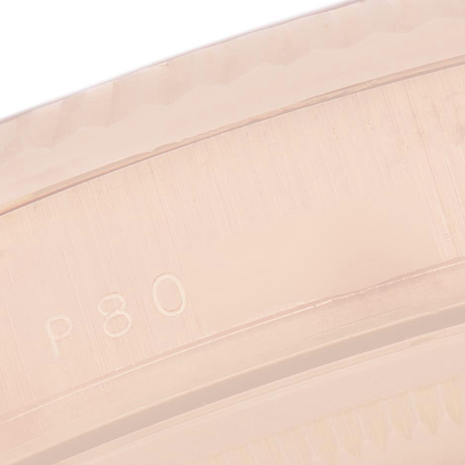 The image shows a close-up of the edge and engravings on the bezel of a Rolex President 118235 Men's Rose Gold Pink Dial 118235 Men's Rose Gold Pink Dial model watch.