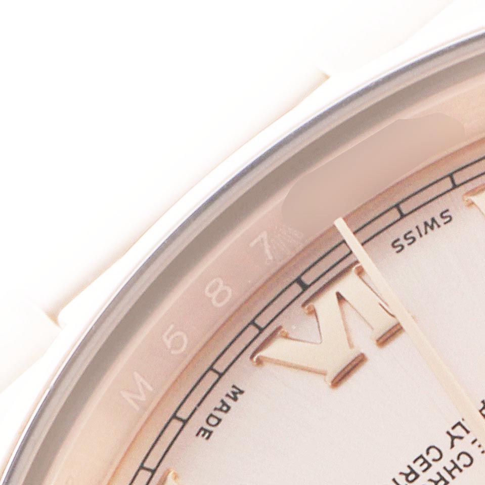 The image shows a close-up of the dial and bezel of a Rolex President 118205 Men's Rose Gold Pink Dial 118205 Men's Rose Gold Pink Dial watch from an oblique angle, highlighting roman numerals and part of the text.