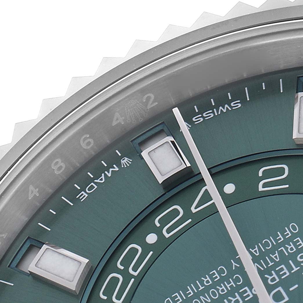 The image shows a close-up of the Rolex Sky-Dweller 336934 Men's Stainless Steel Green Dial 336934 Men's Stainless Steel Green Dial's dial, focusing on the hour markers, minute hand, and part of the bezel.