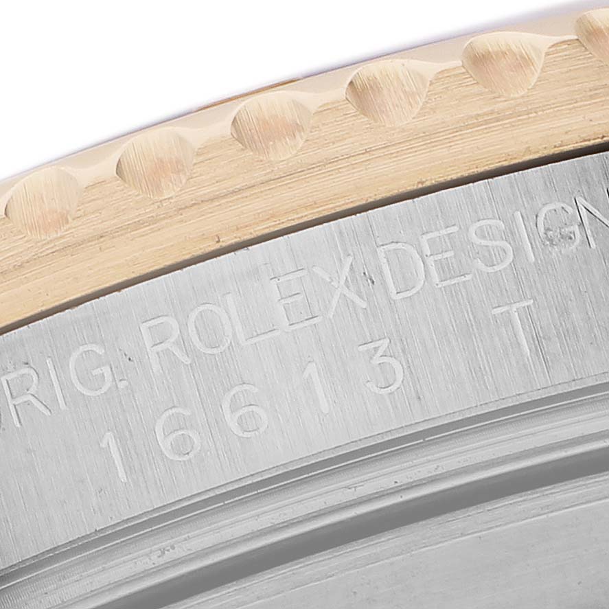 The image shows a close-up of the side of a Rolex Submariner 16613 Men's Steel and Gold (two tone) Blue Dial, highlighting the engraved bezel and case details.