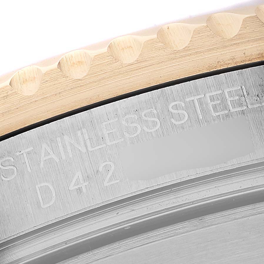 The image shows a close-up of the Rolex Submariner 16613 Men's Steel and Gold (two tone) Blue Dial's edge, focusing on the bezel and engraved case back.