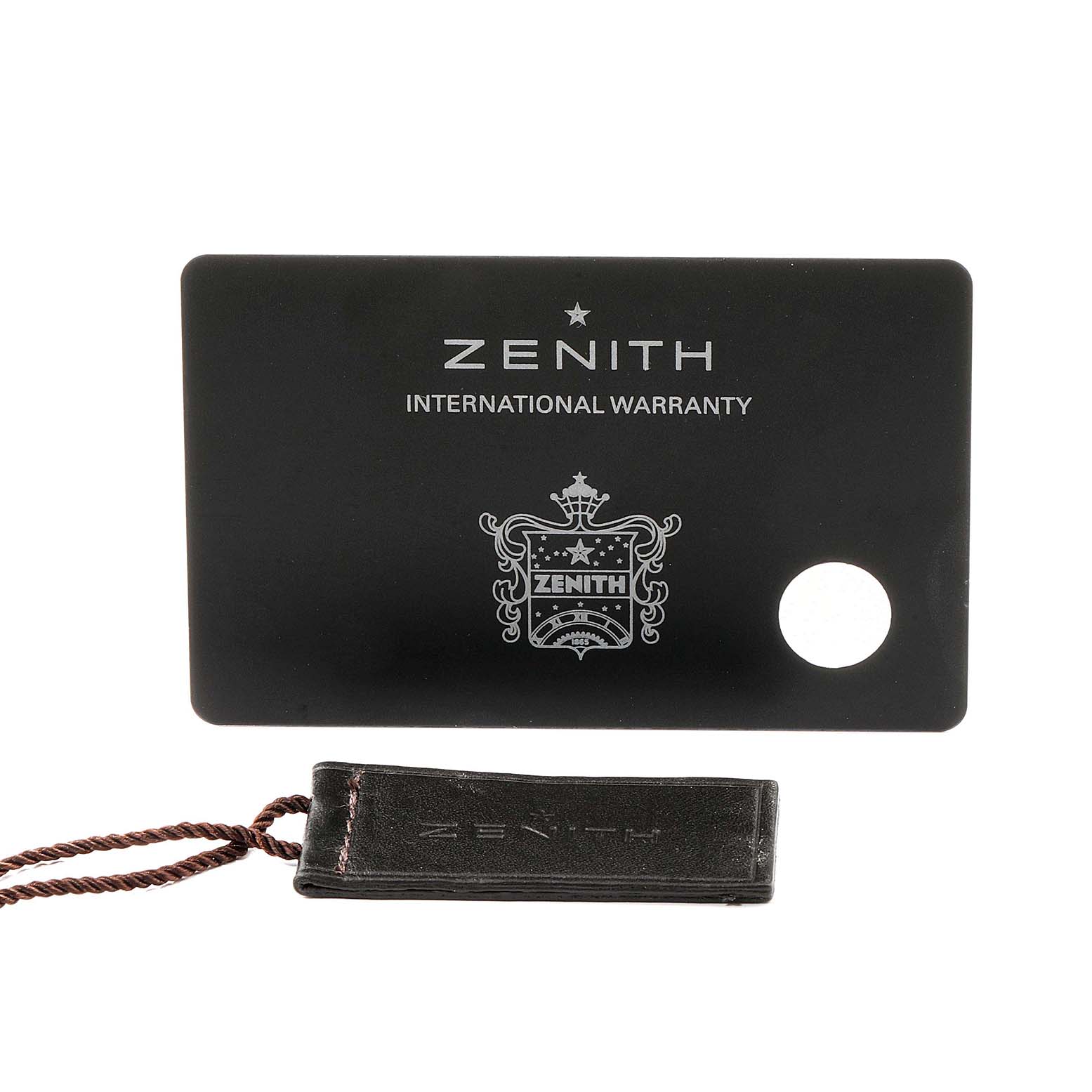 The image shows a Zenith warranty card and tag for the El Primero model.