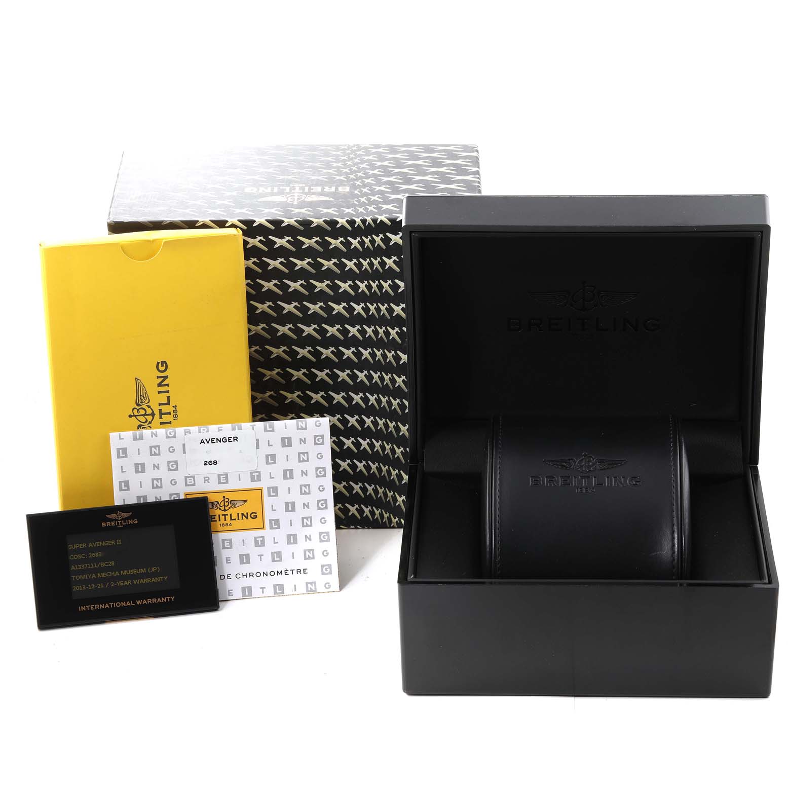 The image shows the box, warranty cards, and packaging for an Avenger model by Breitling, displayed from a front angle.