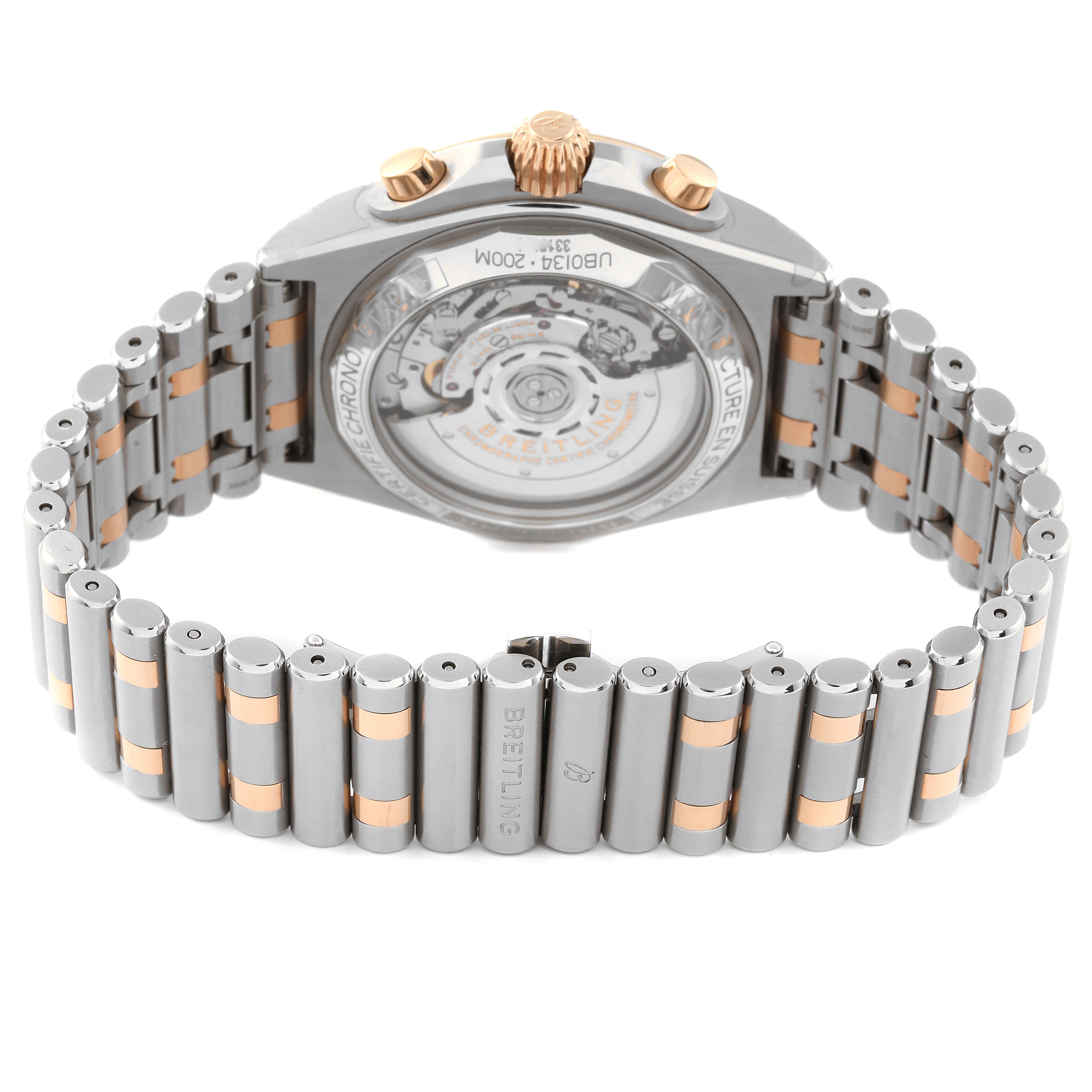 This image shows the Breitling Chronomat UB0134 Men's Steel and Gold (two tone) Grey Dial UB0134 Men's Steel and Gold (two tone) Grey Dial watch from a rear angle, highlighting its transparent back case and metal bracelet.