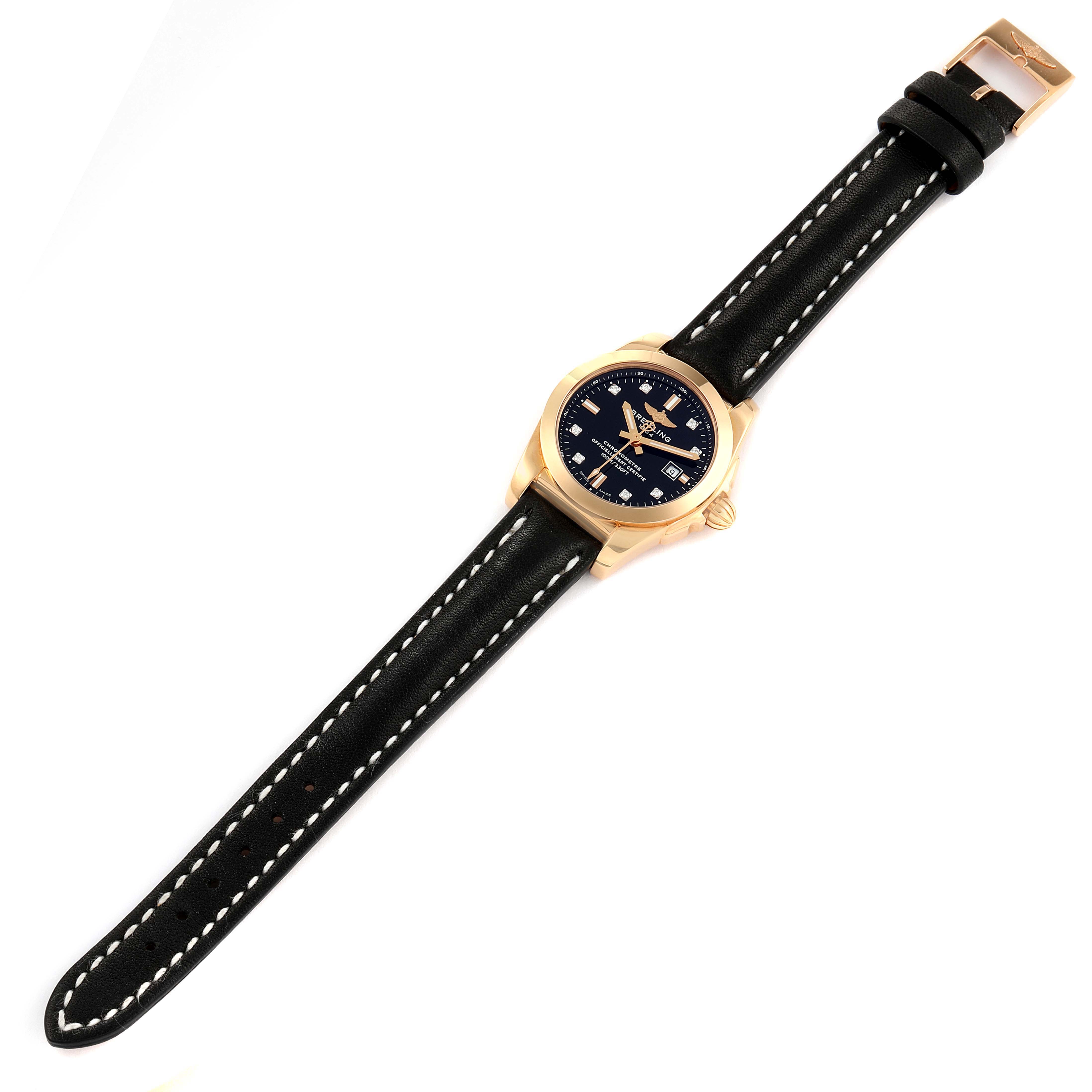 The Breitling H72348 Women's Rose Gold Black Dial H72348 Women's Rose Gold Black Dial Galactic 29 18k Rose Gold Diamond Dial Ladies Watch H72348 is shown from a top-down angle, displaying the black strap and diamond-studded dial.