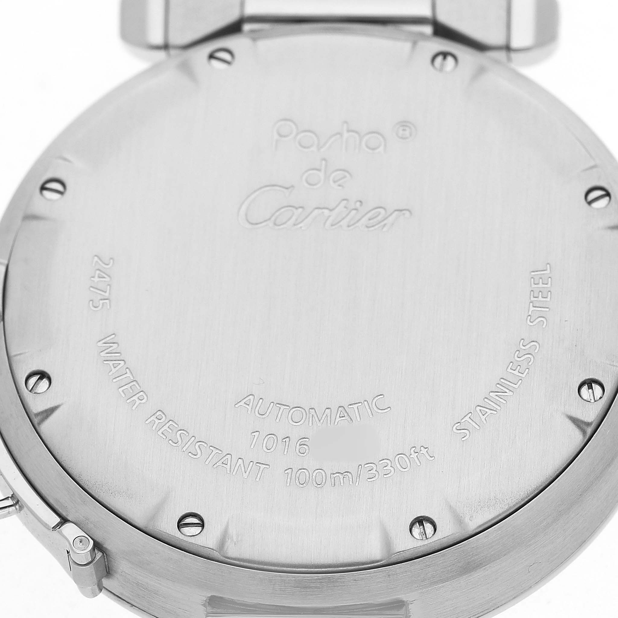 The image shows the stainless steel back of a Cartier Pasha W31044M7 Men's Stainless Steel White Dial watch with engraved details and screws.