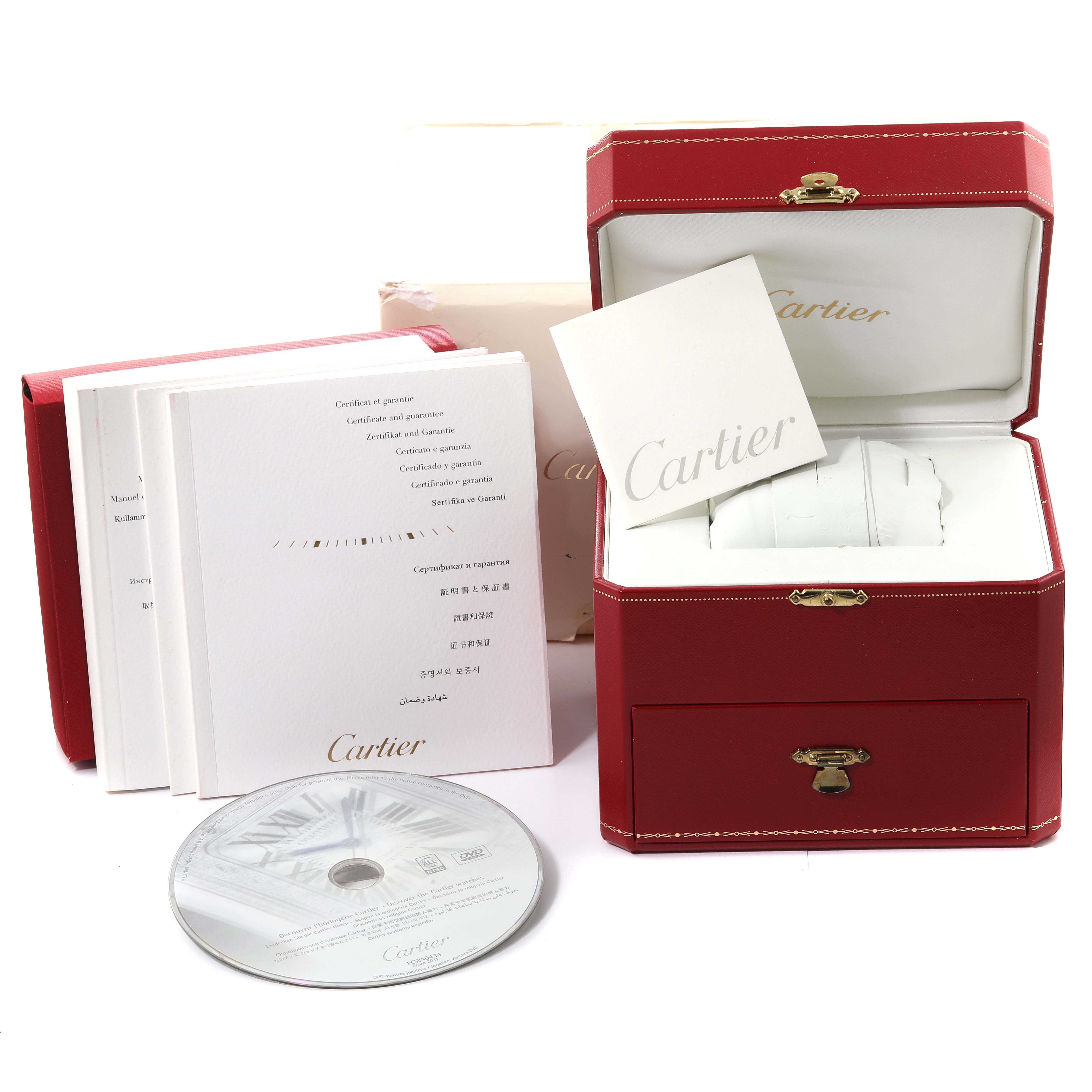 This image displays the packaging and accessories for a Cartier Tank Americaine WB7073L1 Women
s White Gold Silver Dial WB7073L1 Women
s White Gold Silver Dial model, including a box, booklets, and a CD.