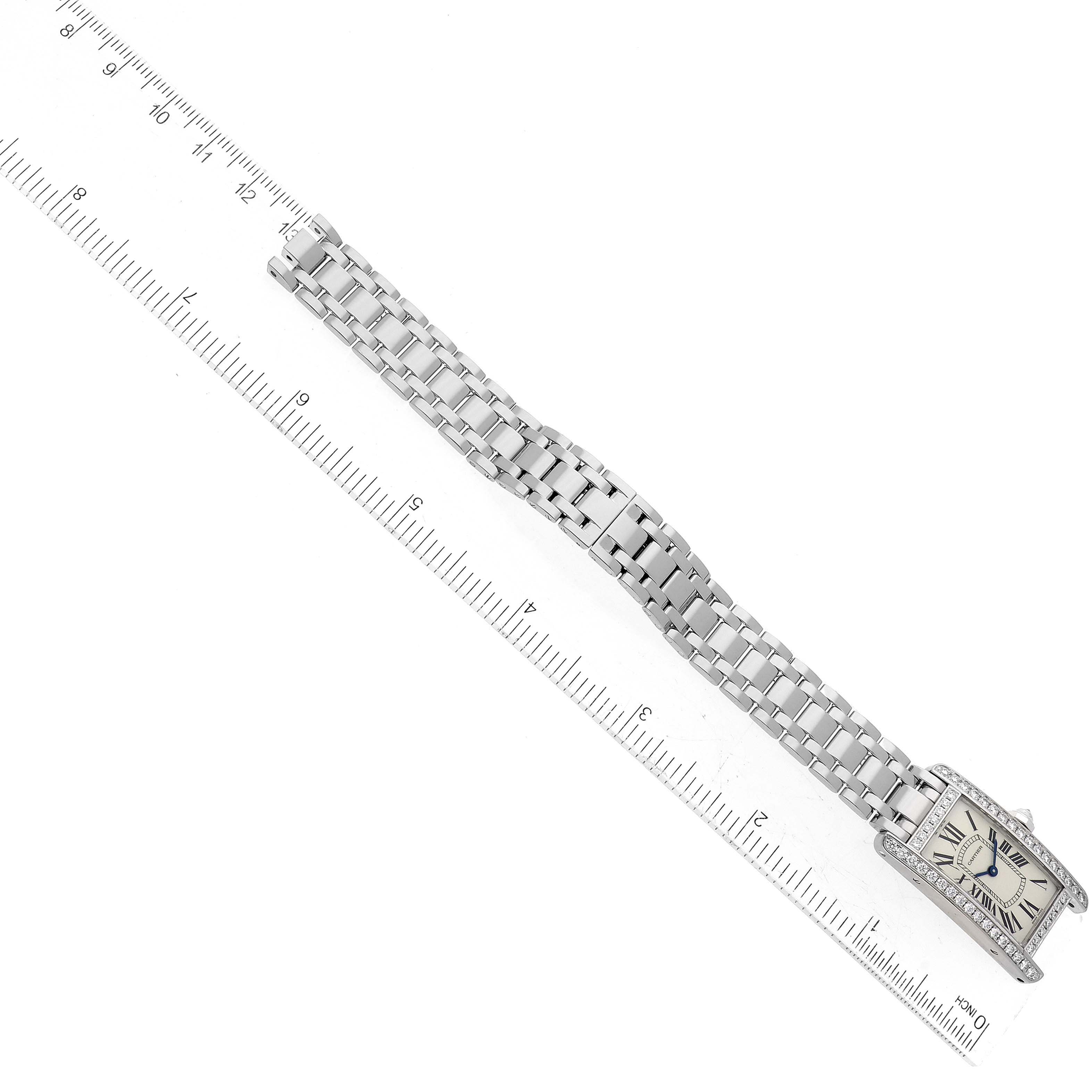 The image shows a Cartier Tank Americaine WB7073L1 Women
s White Gold Silver Dial WB7073L1 Women
s White Gold Silver Dial watch laid flat next to a ruler, displaying its face and bracelet.