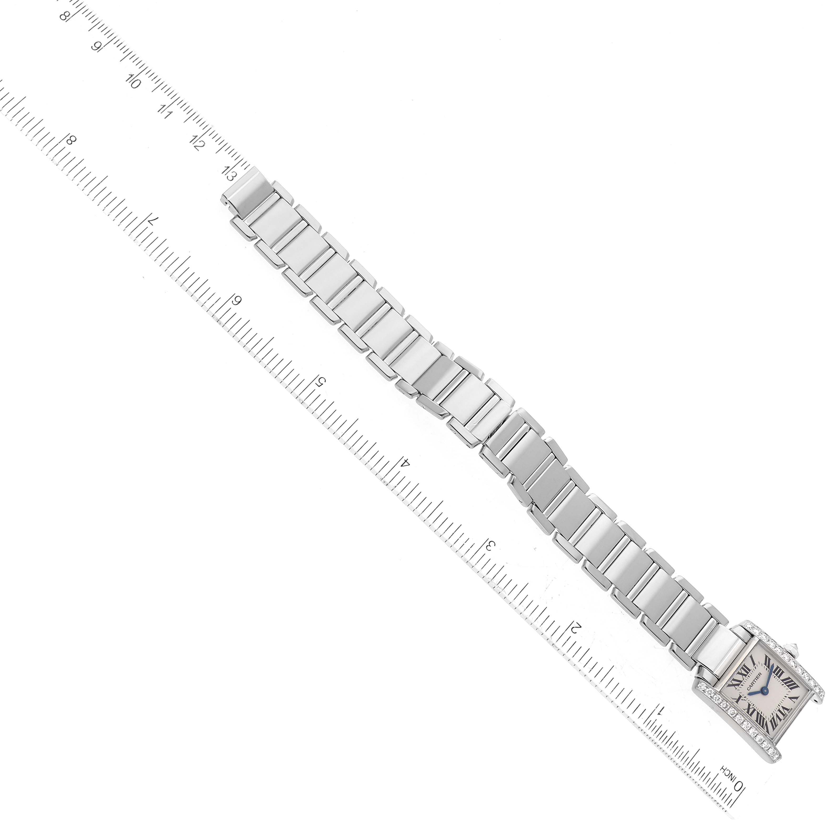 The image shows a top-down view of a Cartier Tank Française watch, highlighting the face and full bracelet against a measuring ruler.