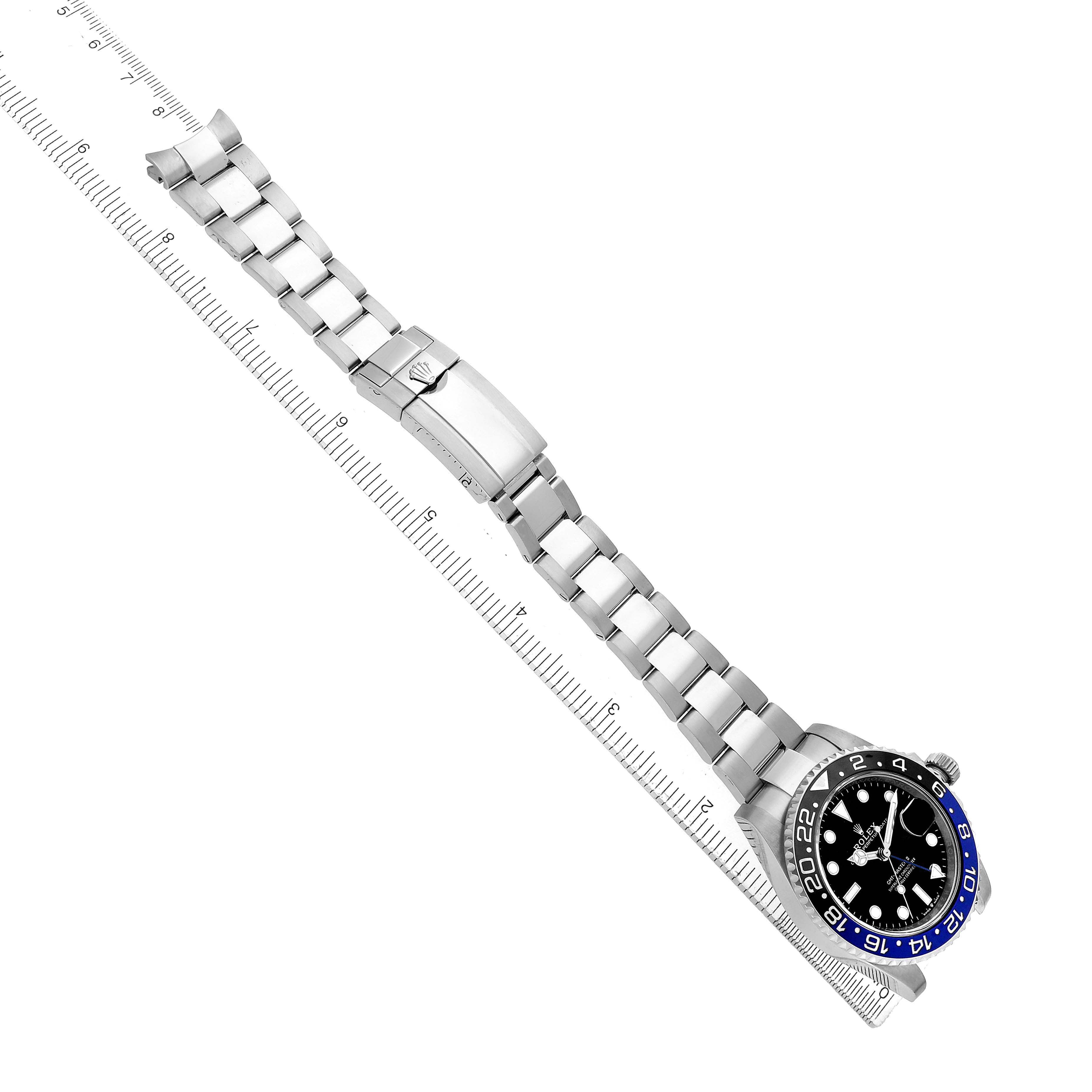 The Rolex GMT-Master 126710BLNR Men's Stainless Steel Black Dial watch is shown from a top-down angle, displaying the face, bezel, and full bracelet with a ruler for scale.