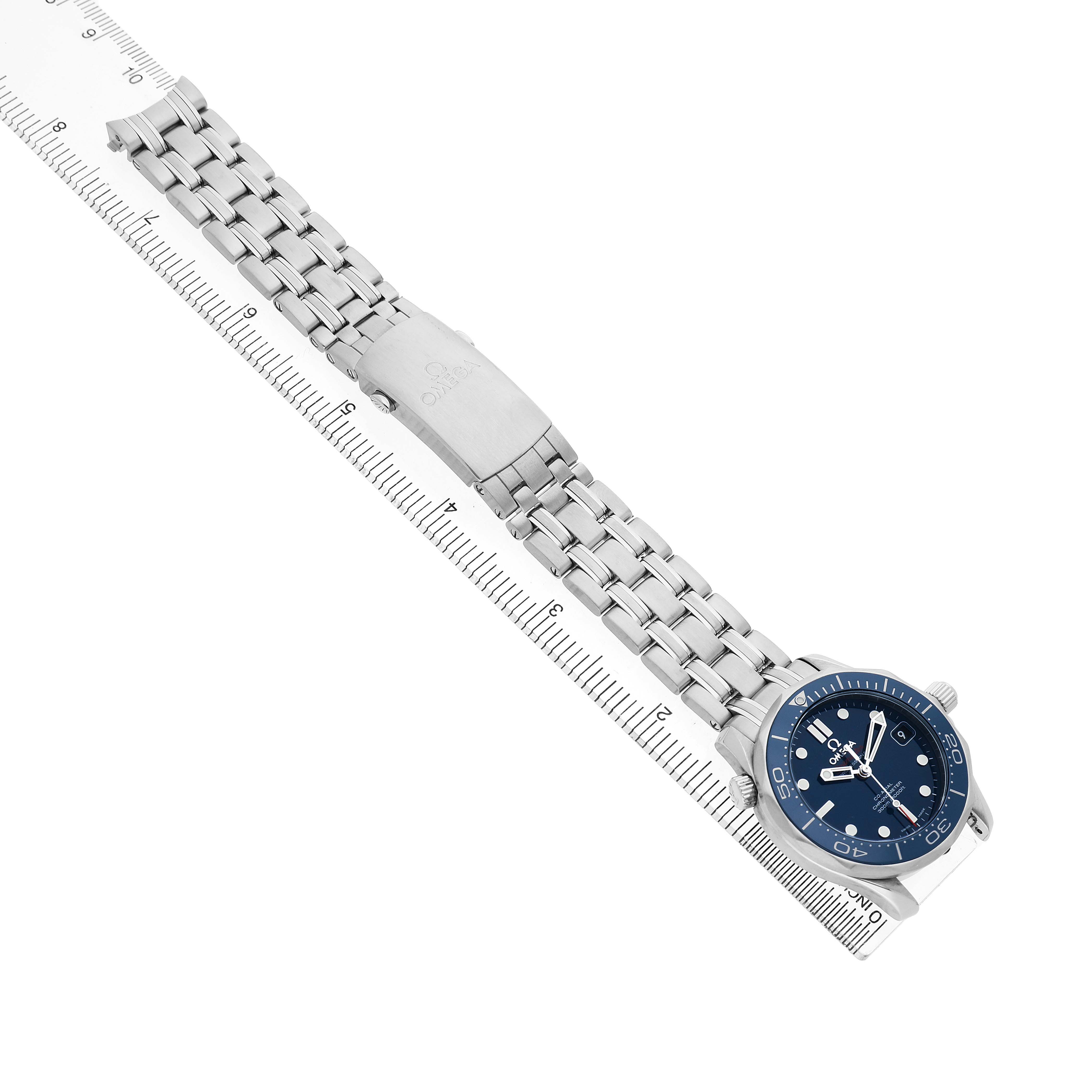 The Omega Seamaster 212.30.36.20.03.001 Men's Stainless Steel Blue Dial watch is shown from above, highlighting the face, bracelet, and clasp next to a ruler for scale.