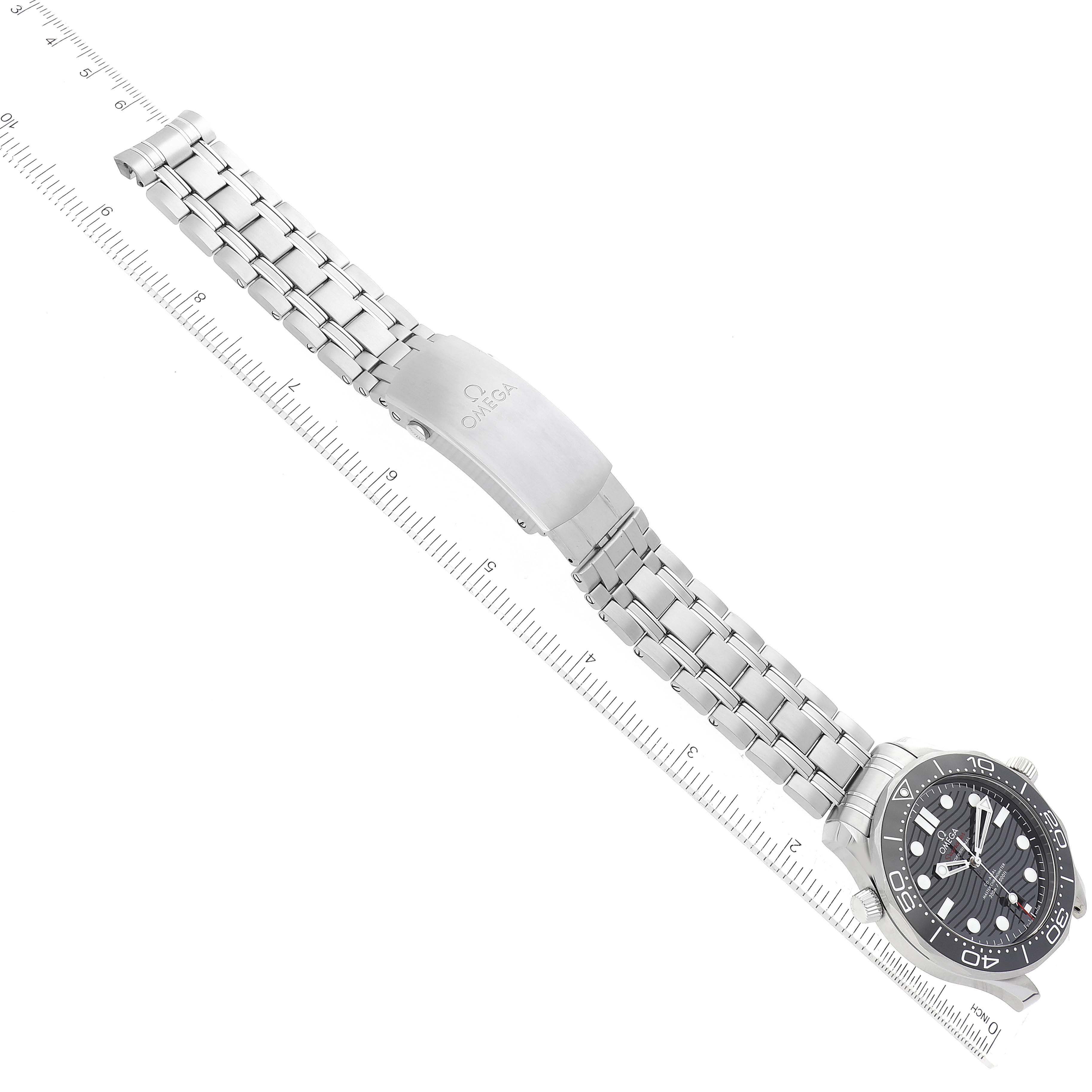 The image shows an Omega Seamaster 210.30.42.20.01.001 Men
s Stainless Steel Black Dial 210.30.42.20.01.001 Men
s Stainless Steel Black Dial watch laid flat with the face, metal bracelet, and clasp visible alongside a measuring scale.