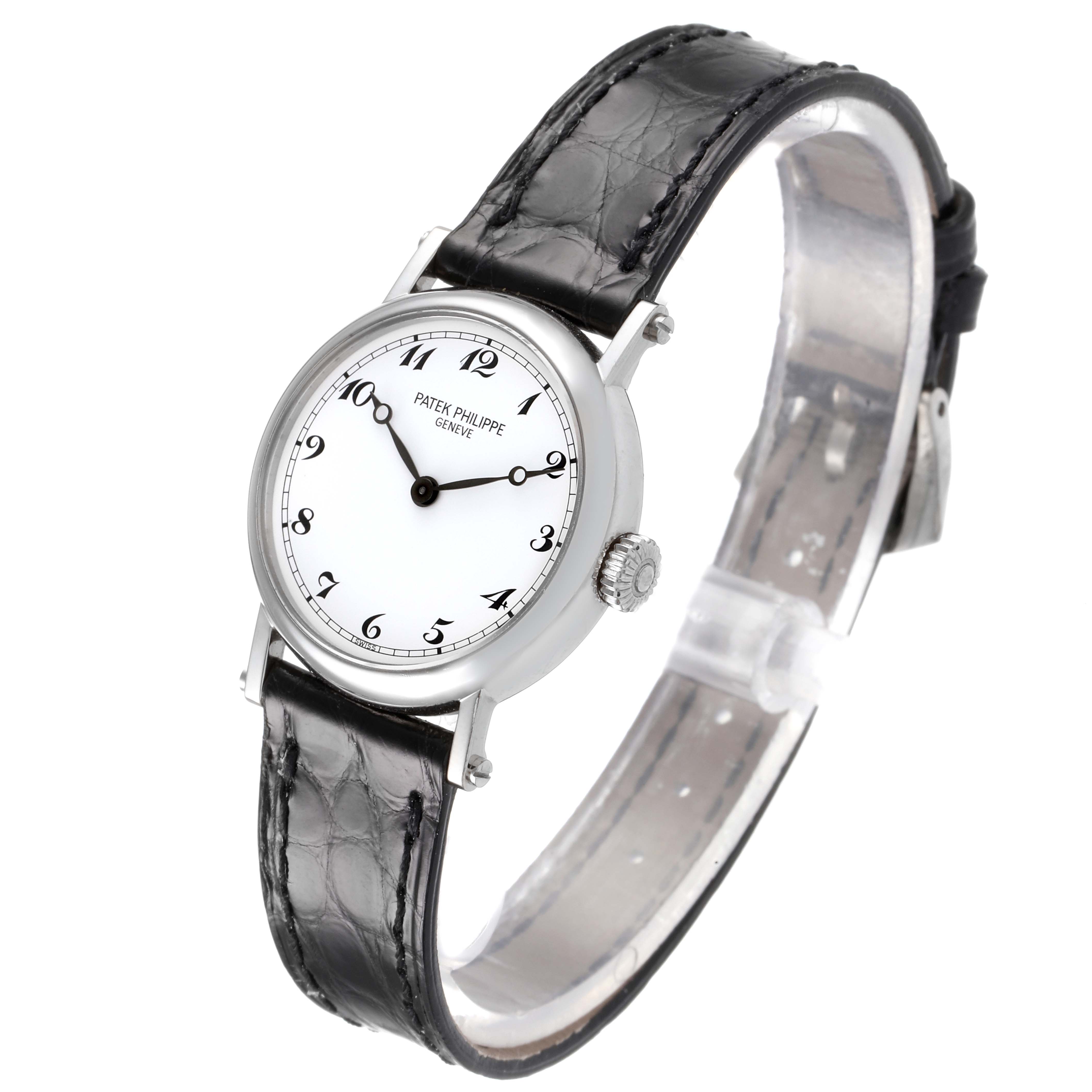 The Calatrava model by Patek Philippe is shown at a slightly angled side view, displaying the watch face, crown, and leather strap.