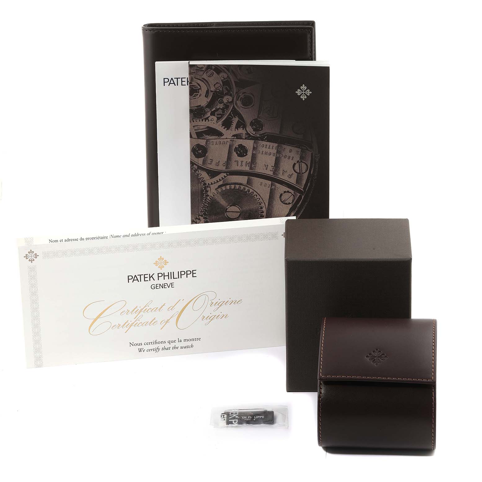 The image shows accessories for a Patek Philippe Calatrava 6119 Men's White Gold Grey Dial 6119 Men's White Gold Grey Dial, including a booklet, certificates, a box, and a leather watch case.