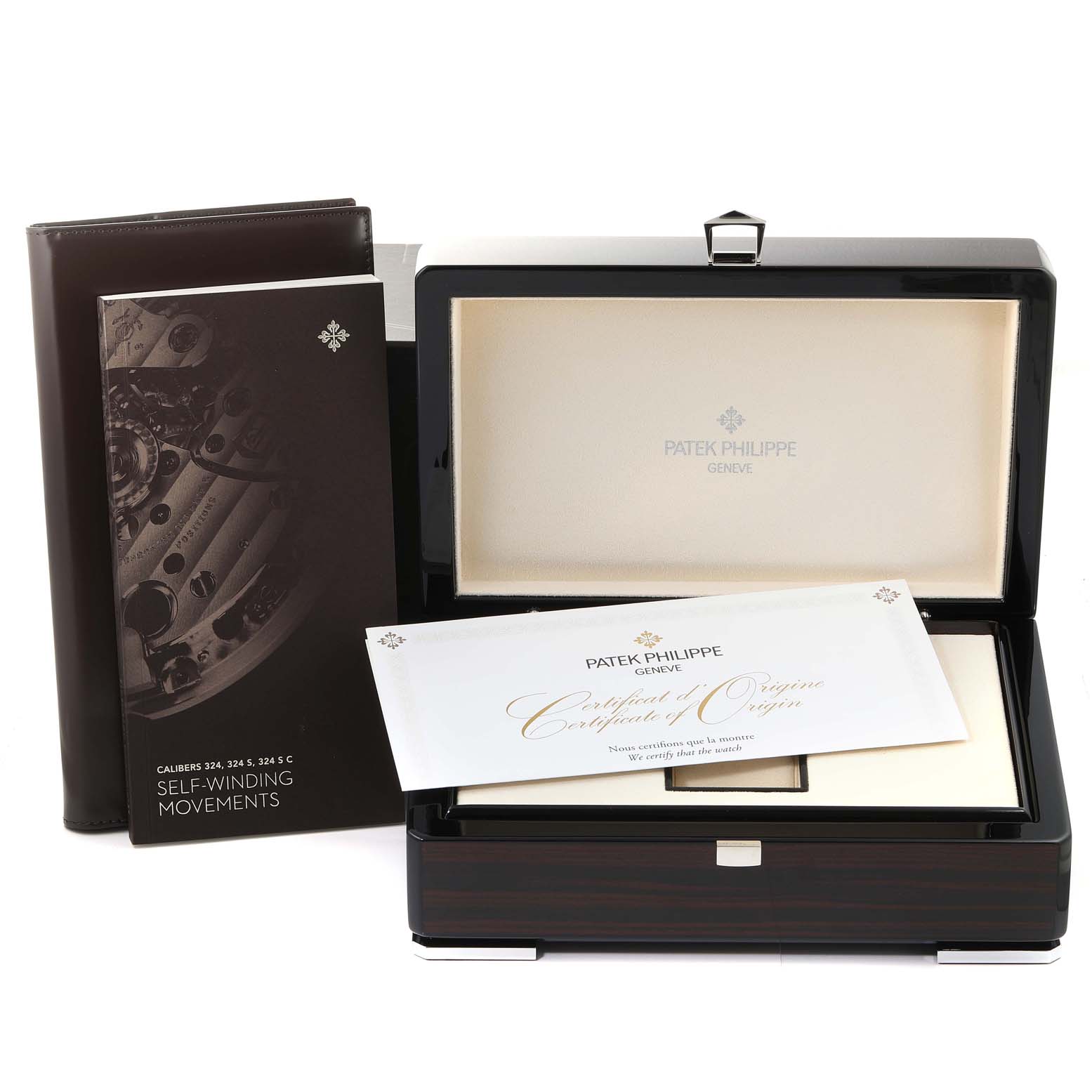 The image shows a Patek Philippe Nautilus 7118/1A -010 Men's Stainless Steel Silver Dial 7118/1A -010 Men's Stainless Steel Silver Dial watch's box, certificate of origin, and an instruction manual from a slightly elevated angle.