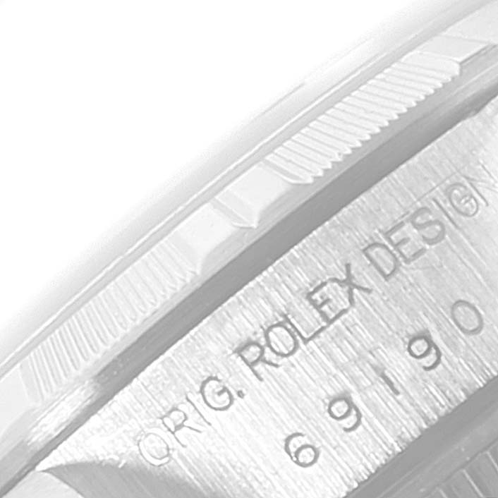 The image shows the engraved side and part of the bezel of a Rolex Date 69190 Women's Stainless Steel Black Dial 69190 Women's Stainless Steel Black Dial model watch.