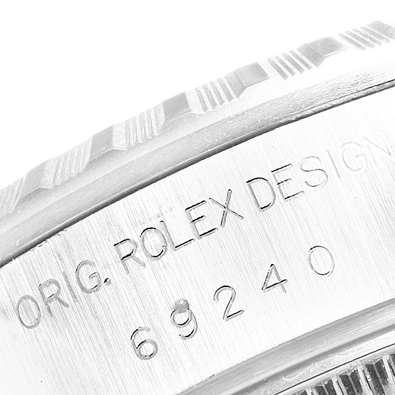 The image shows a close-up of the Rolex Date 69240 Women's Stainless Steel White Dial 69240 Women's Stainless Steel White Dial model's fluted bezel and part of the engraved case.