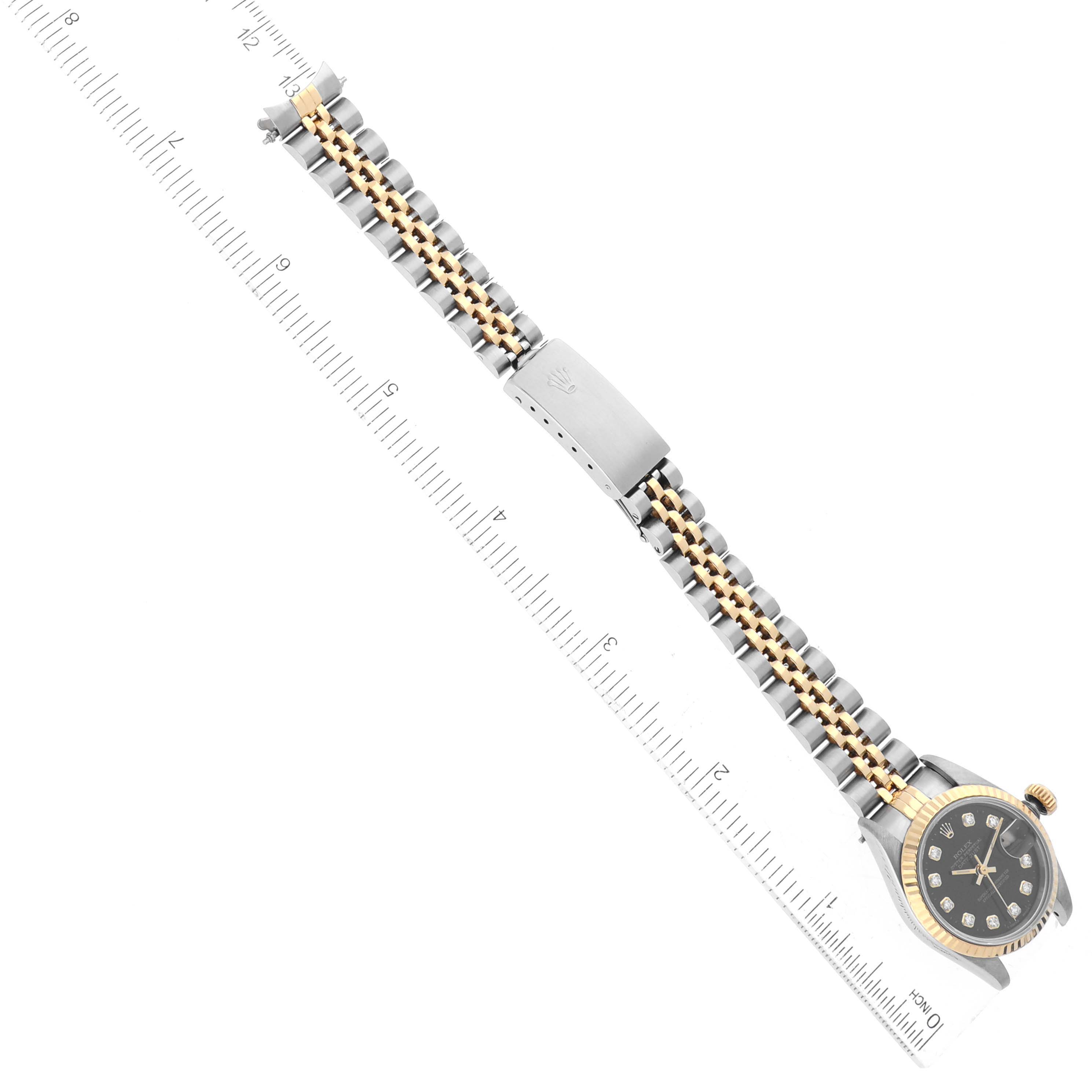 This image shows a top view of a Rolex Datejust 69173G Women's Steel and Gold (two tone) Black Dial 69173G Women's Steel and Gold (two tone) Black Dial watch, highlighting its band and face with a ruler for scale.