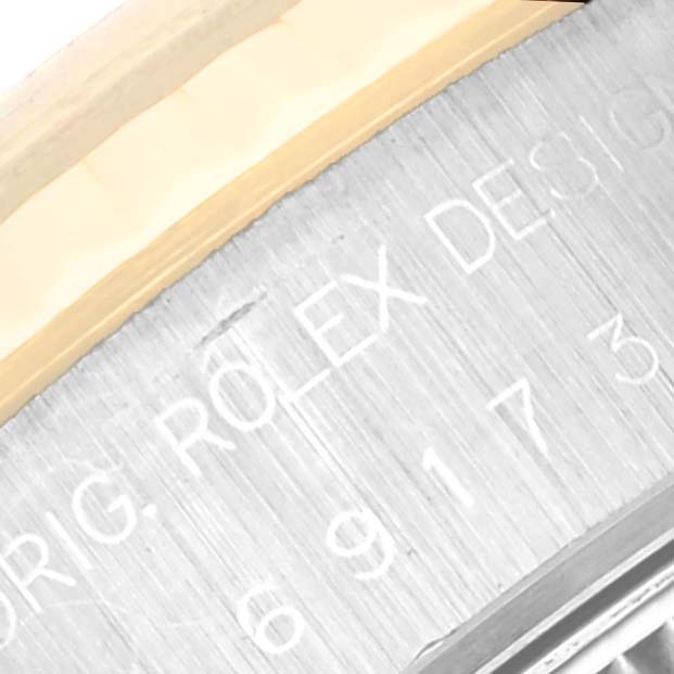 The image shows a close-up of the case and engraved text of a Rolex Datejust 69173G Women's Steel and Gold (two tone) Black Dial 69173G Women's Steel and Gold (two tone) Black Dial watch.