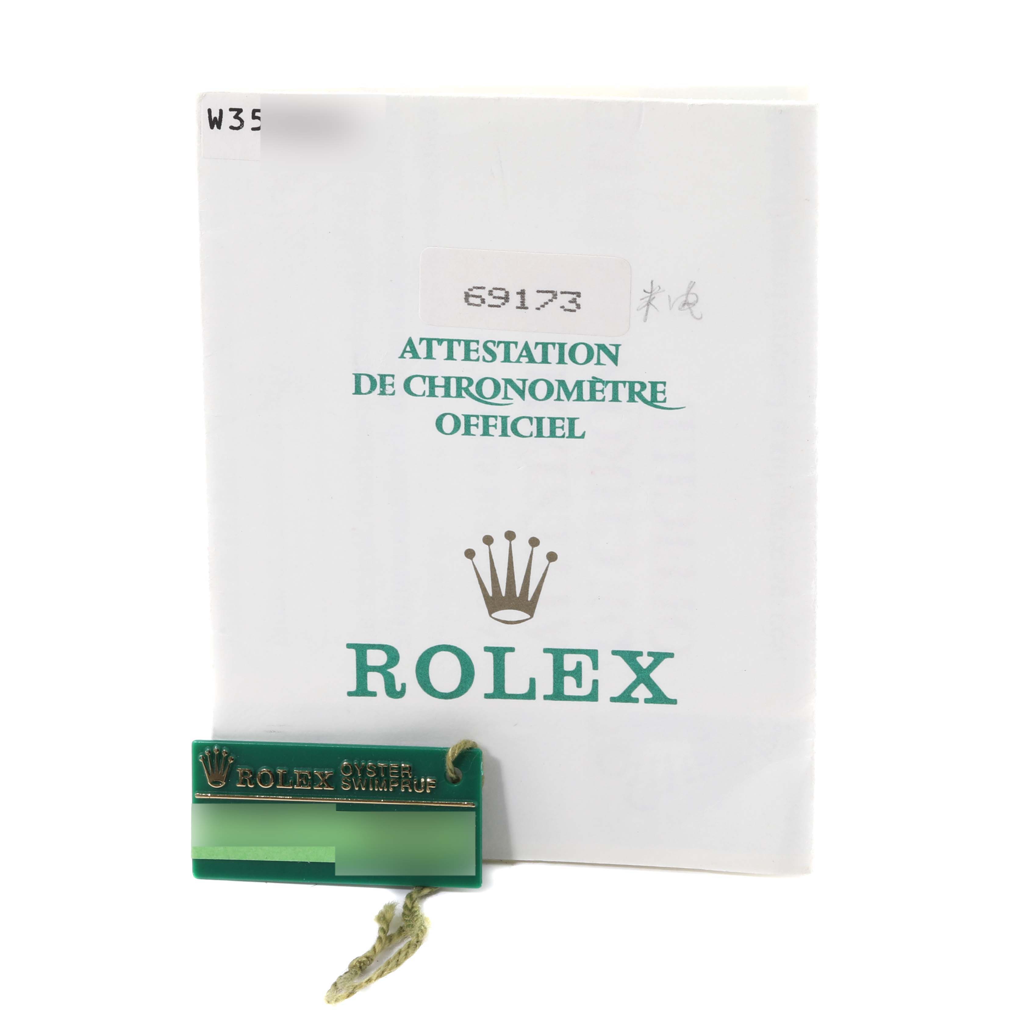 The image shows the certification booklet and a green tag from the Rolex Datejust 69173 Women's Steel and Gold (two tone) White Dial 69173 Women's Steel and Gold (two tone) White Dial model.