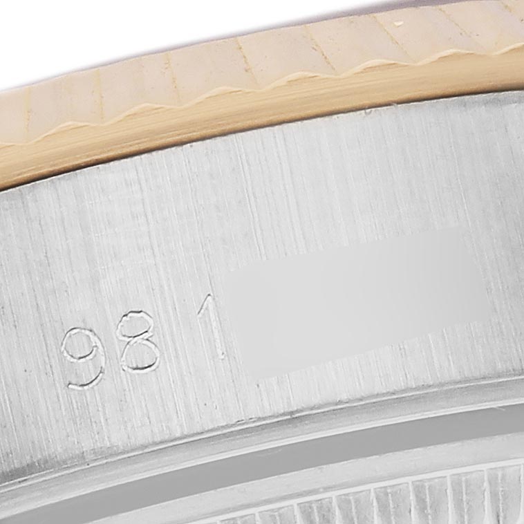 The image shows a close-up of the Rolex Datejust 69173 Women
s Steel and Gold (two tone) Champagne Dial 69173 Women
s Steel and Gold (two tone) Champagne Dial case, highlighting the fluted bezel and partial serial number.