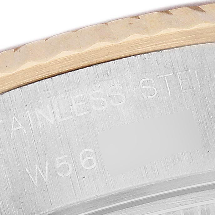 The image shows a close-up of the side of a Rolex Datejust 69173 Women
s Steel and Gold (two tone) Champagne Dial 69173 Women
s Steel and Gold (two tone) Champagne Dial, highlighting the engraved stainless steel case and part of the fluted bezel.
