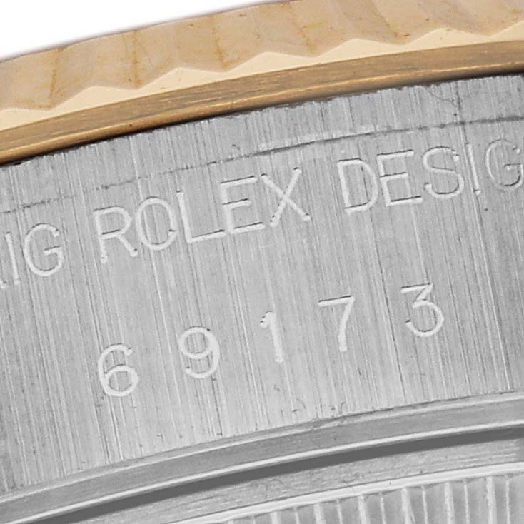 This image shows a close-up of the side of a Rolex Datejust 79173 Women's Steel and Gold (two tone) Champagne Dial 79173 Women's Steel and Gold (two tone) Champagne Dial watch, focusing on the engraved text and part of the bezel.