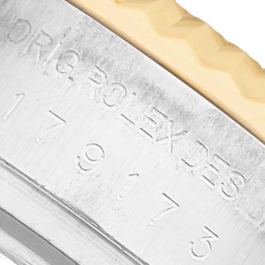 The image shows the engraved side case of a Rolex Datejust 179173 Women's Steel and Gold (two tone) White Dial watch, featuring part of the serial number and logo.