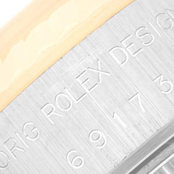 The image shows a close-up of the engraved text on the side of the bezel of a Rolex Datejust 69173 Women's Steel and Gold (two tone) White Dial 69173 Women's Steel and Gold (two tone) White Dial watch.