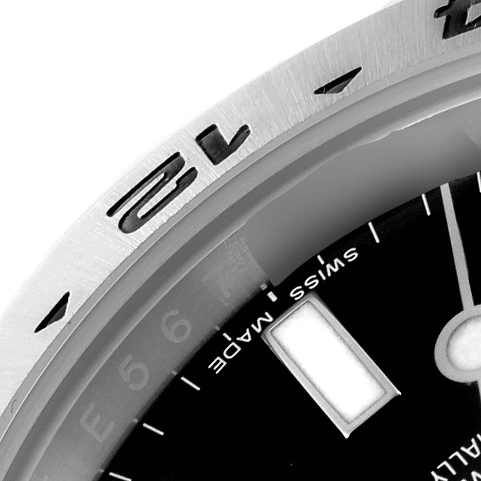 The image shows a close-up view of the bezel and part of the dial of a Rolex Explorer 216570 Men
s Stainless Steel Black Dial 216570 Men
s Stainless Steel Black Dial watch.