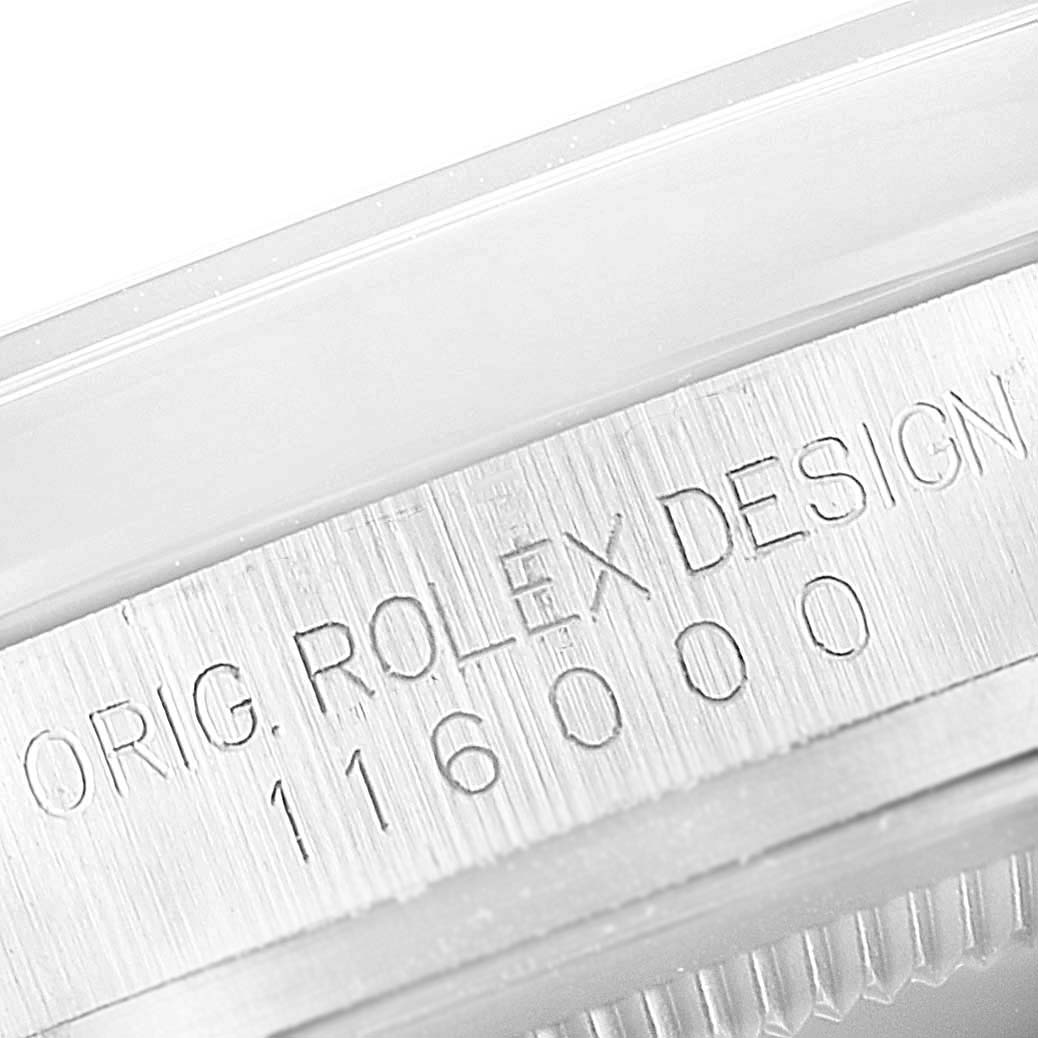 The image shows a close-up of the case side engraving on a Rolex Oyster Perpetual 116000 Men's Stainless Steel Silver Dial 116000 Men's Stainless Steel Silver Dial watch, displaying model number 116000.