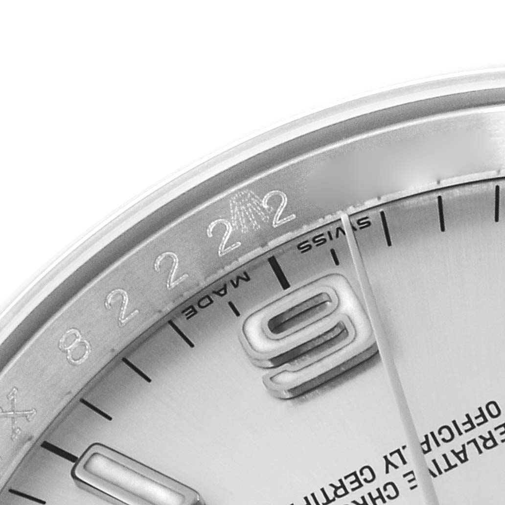 This image shows a close-up shot of the upper-left portion of the dial and bezel of a Rolex Oyster Perpetual 116000 Men's Stainless Steel Silver Dial 116000 Men's Stainless Steel Silver Dial watch.