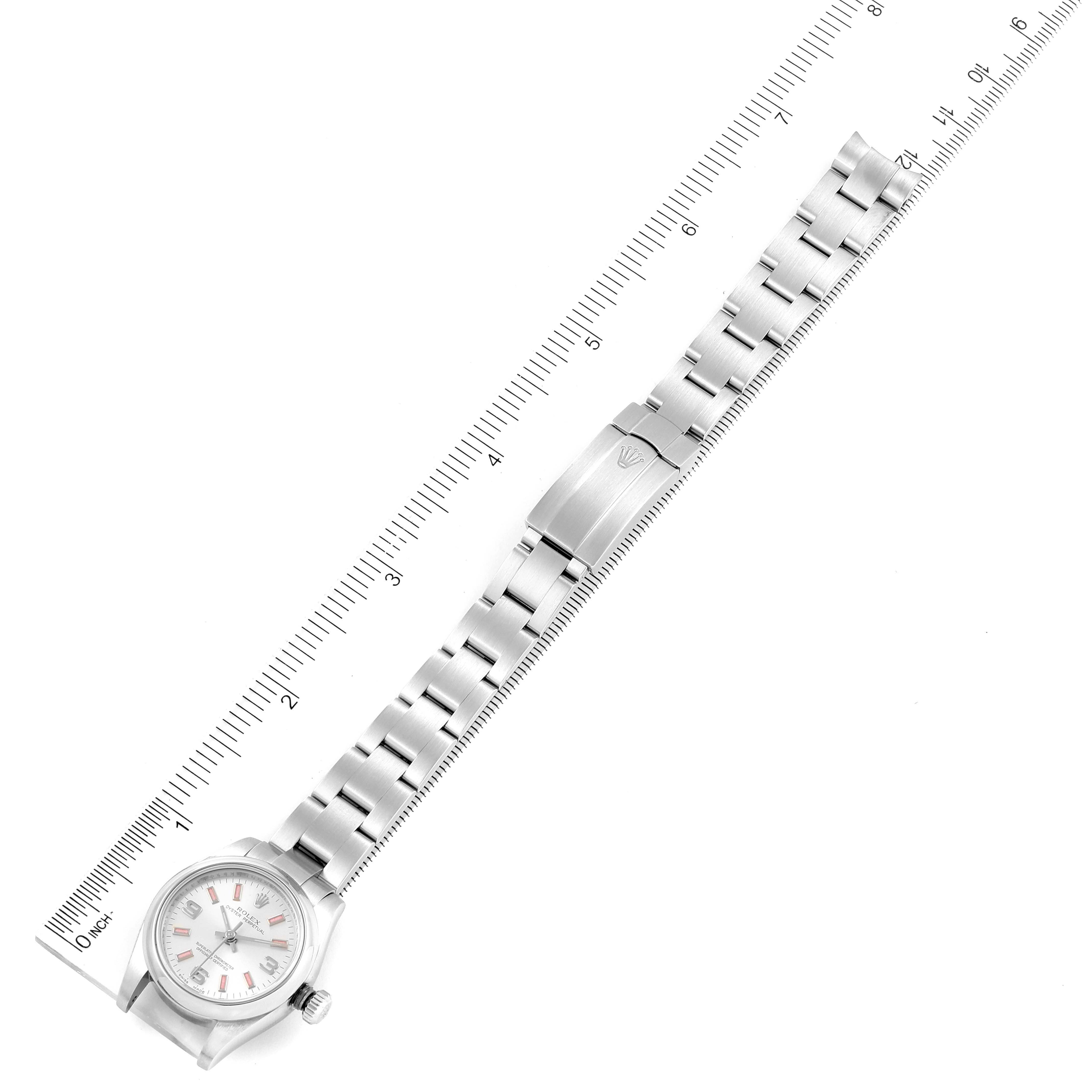 This image shows a Rolex Oyster Perpetual 176200 Women
s Stainless Steel Silver Dial 176200 Women
s Stainless Steel Silver Dial watch laid flat with its bracelet extended next to a ruler for measurement.