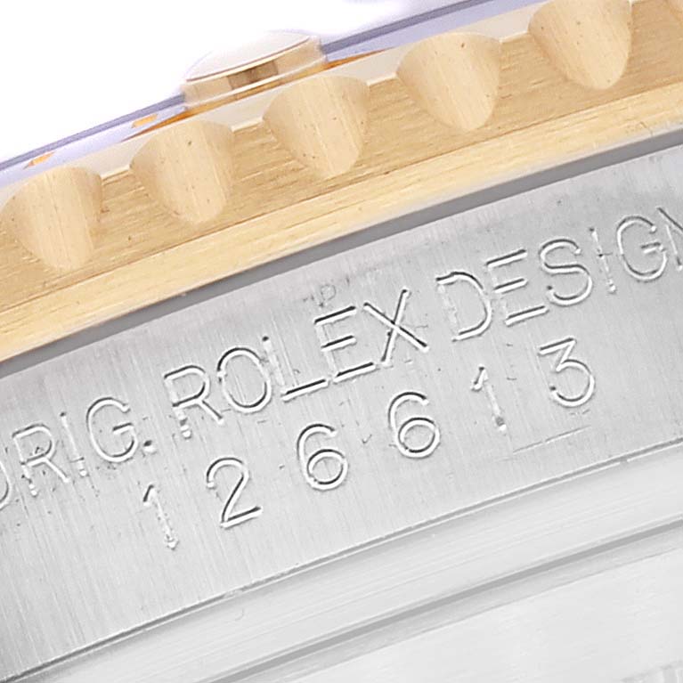 This image shows a close-up of the watch case with the engraving "ORIG. ROLEX DESIGN 126613" on a Rolex Submariner 126613 Men's Steel and Gold (two tone) Blue Dial 126613 Men's Steel and Gold (two tone) Blue Dial.