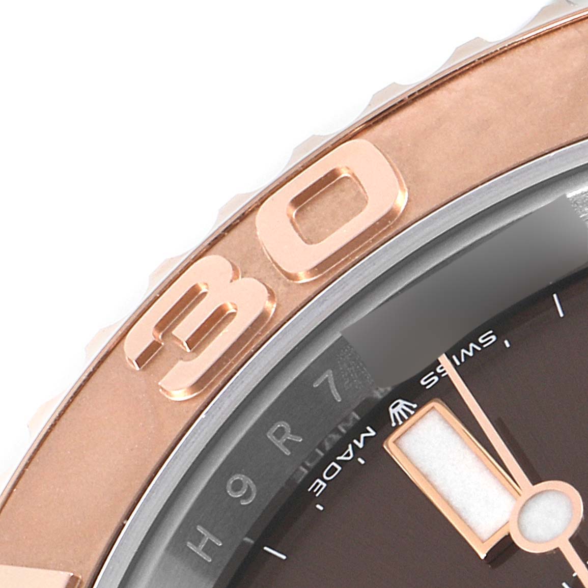 This close-up image shows a partial view of the bezel, dial, and hour marker of a Rolex Yacht-Master 126621 Men's Steel and Gold (two tone) Brown Dial 126621 Men's Steel and Gold (two tone) Brown Dial watch.