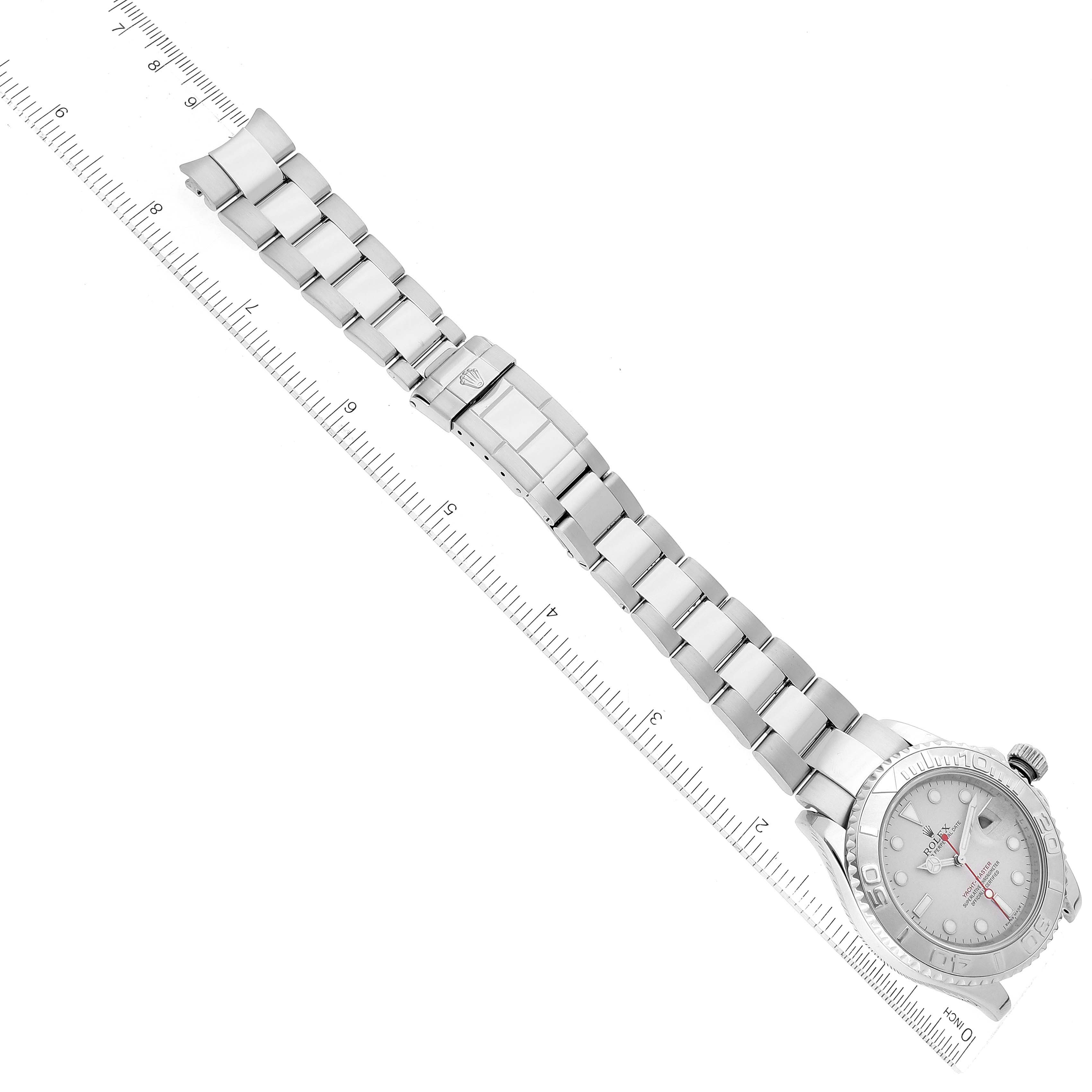 The image shows a top-down view of the full Rolex Yacht-Master 16622 Men
s Stainless Steel Silver Dial 16622 Men
s Stainless Steel Silver Dial watch, including its bracelet and clasp, next to a ruler.