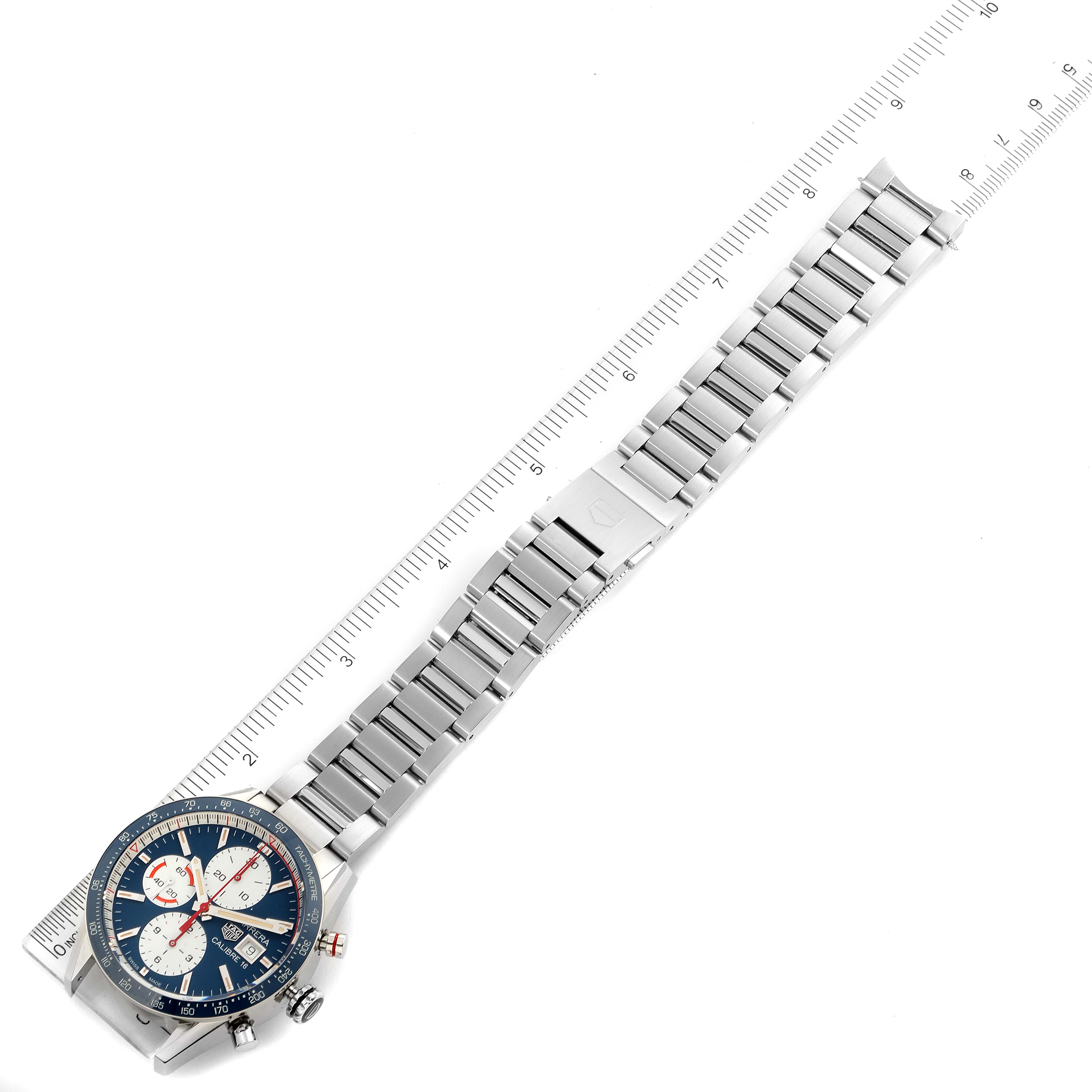 The image shows a top-down view of the Tag Heuer Carrera CV201AR.BA0715 Men's Stainless Steel Blue Dial CV201AR.BA0715 Men's Stainless Steel Blue Dial watch with its full length and metal band extended alongside a ruler.
